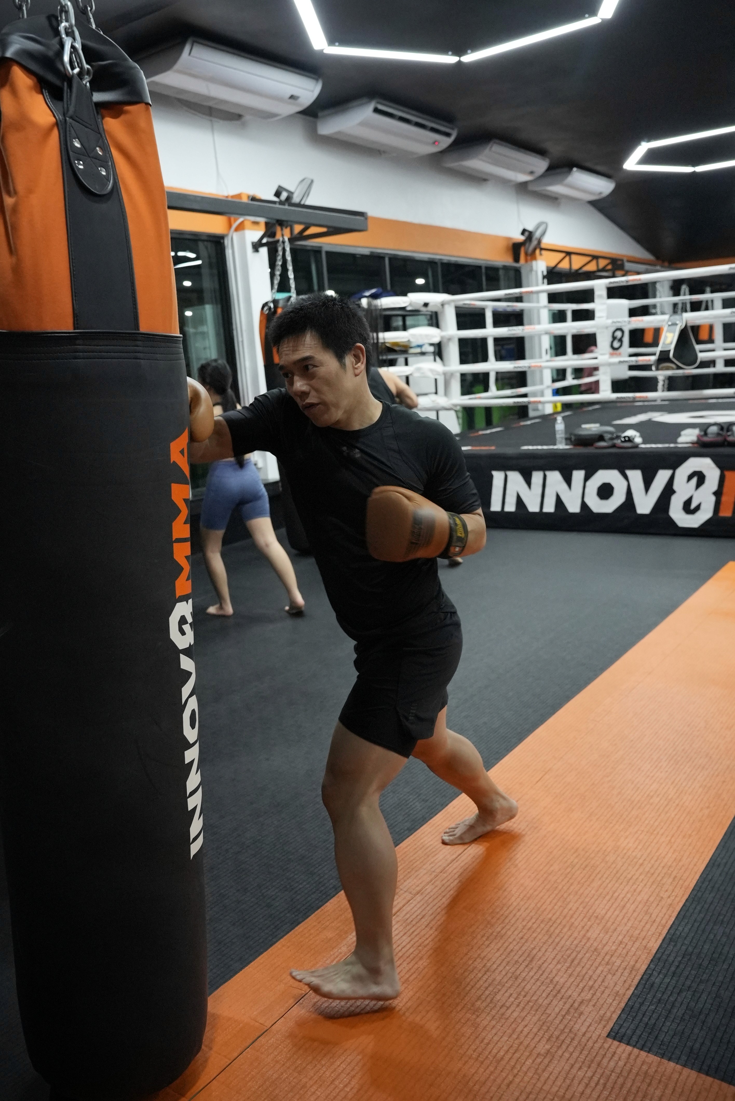Man hitting punch bag at INNOV8 MMA Gym