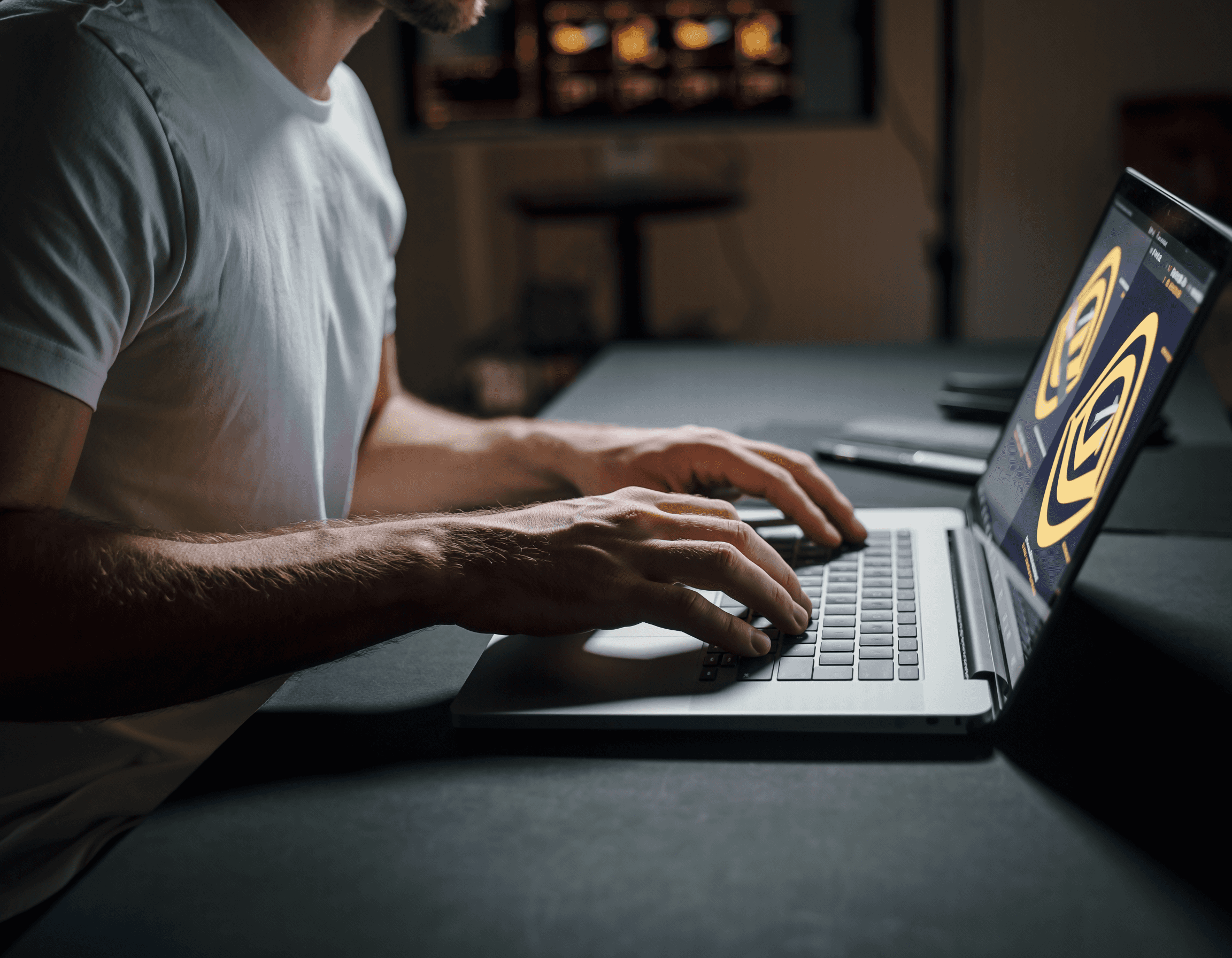 Hands working on a laptop while developing brand design visuals on screen.