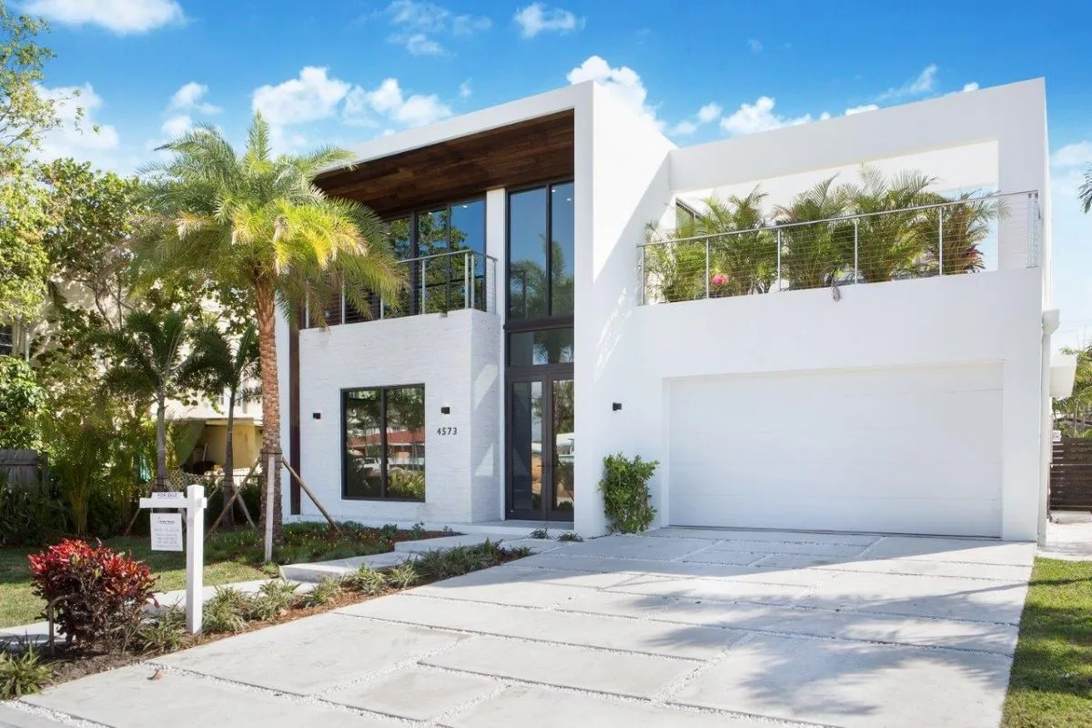 Street view of modern residential home with garage and rooftop terrace in Miami Beach