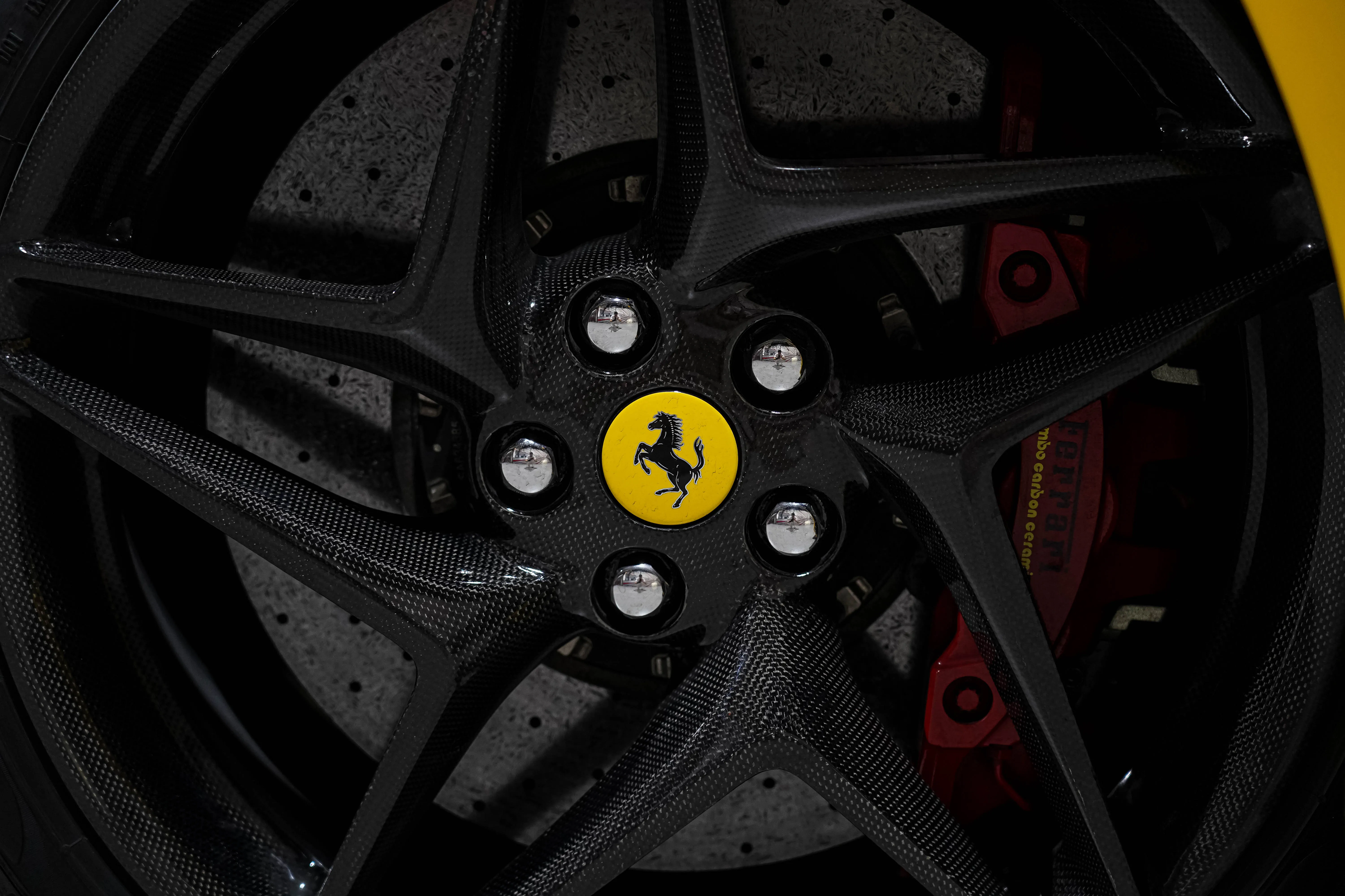 Ferrari F8 Spider carbon fiber wheel and performance tire detail, luxury supercar rental in Dubai