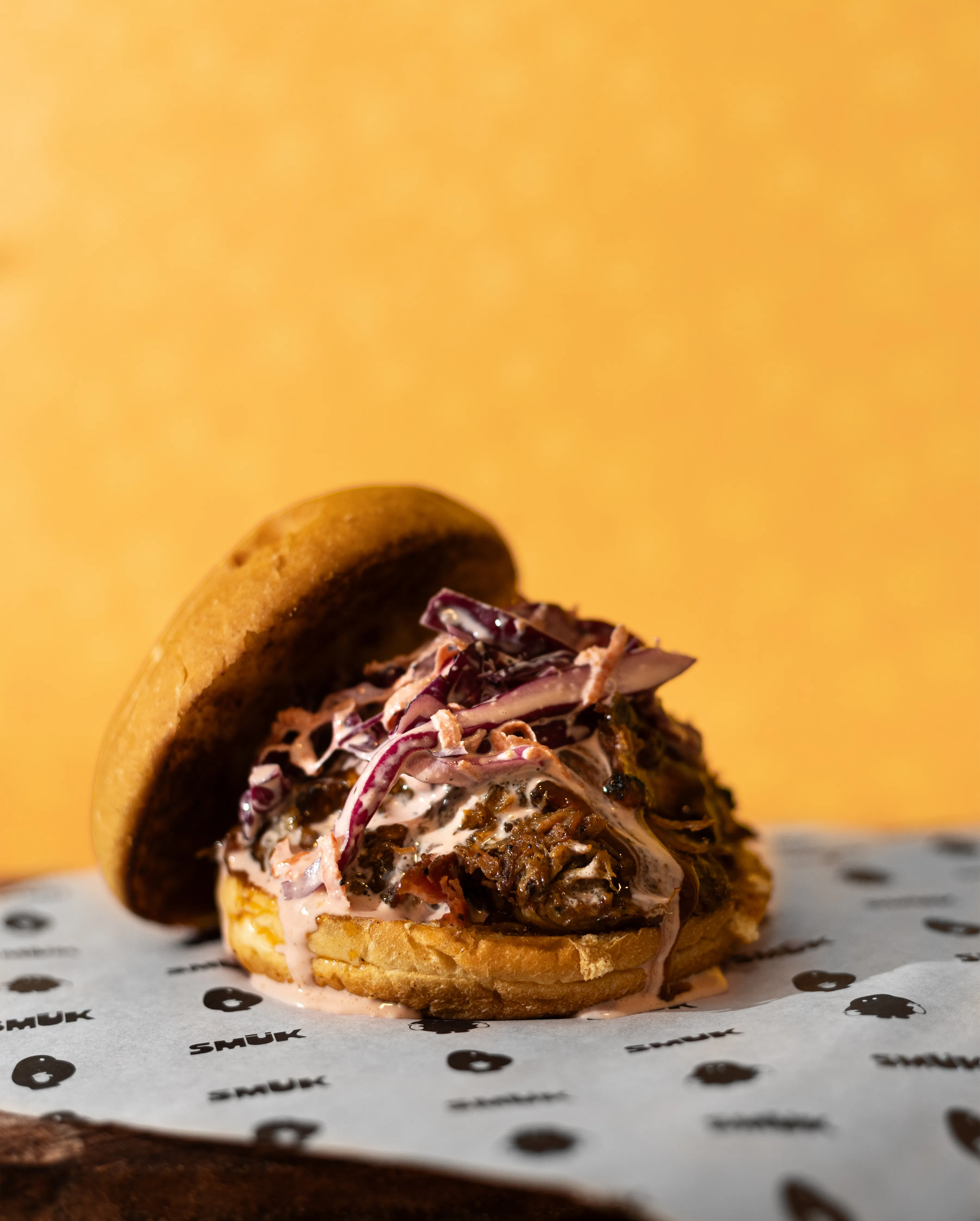 Hamburguesa de pulled pork con fondo amarillo cálido