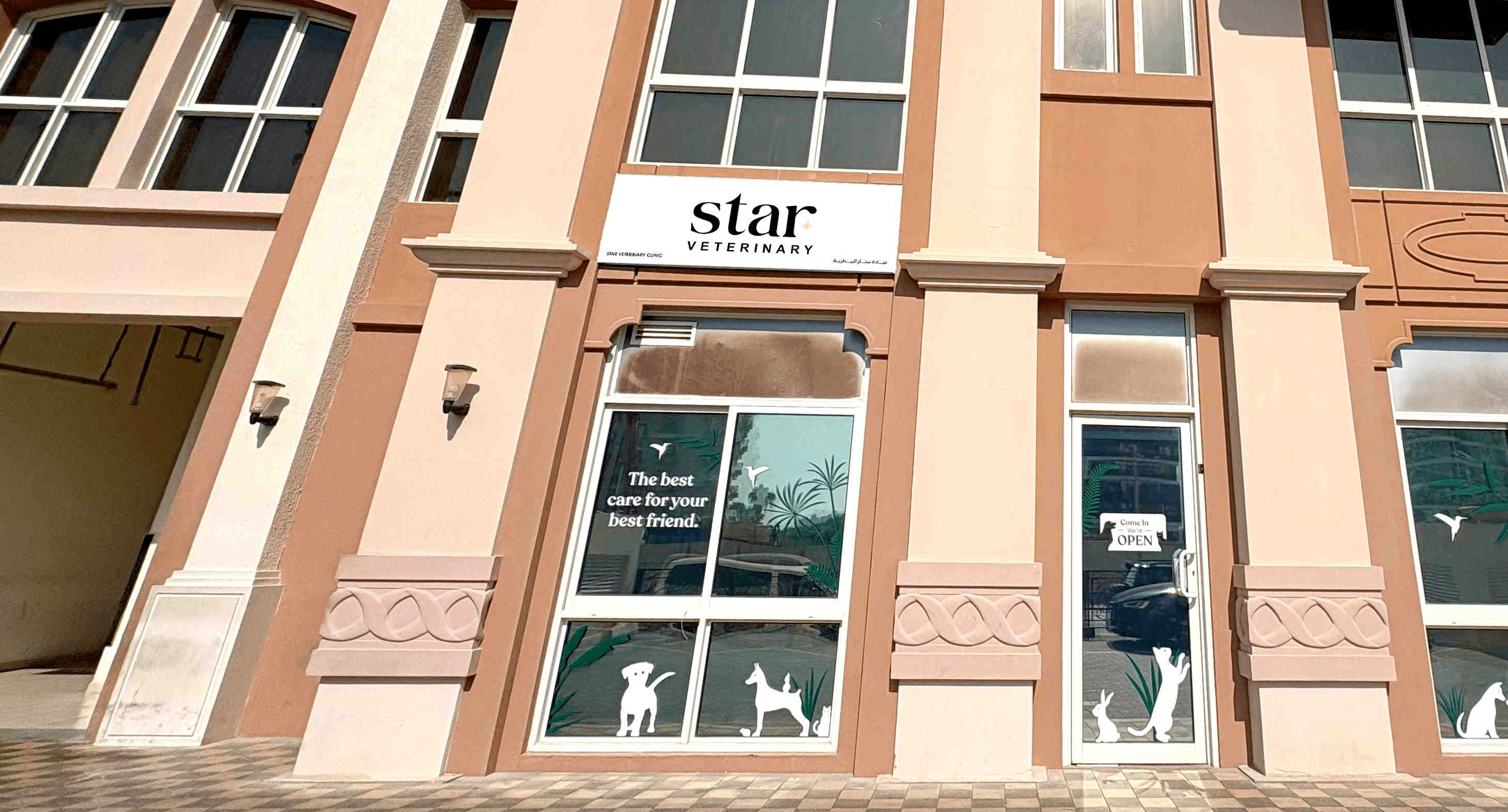 The front of Noble Veterinary Clinic in DIP, Dubai. Our vet clinic features glass doors and windows with reverse silhouettes of pets on the windows surrounding the doors.