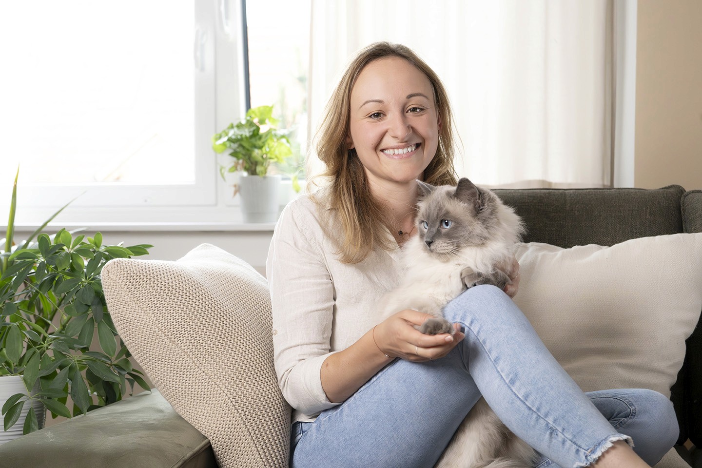 Nicole Rathmayr sitzt auf der Couch mit einer Katze