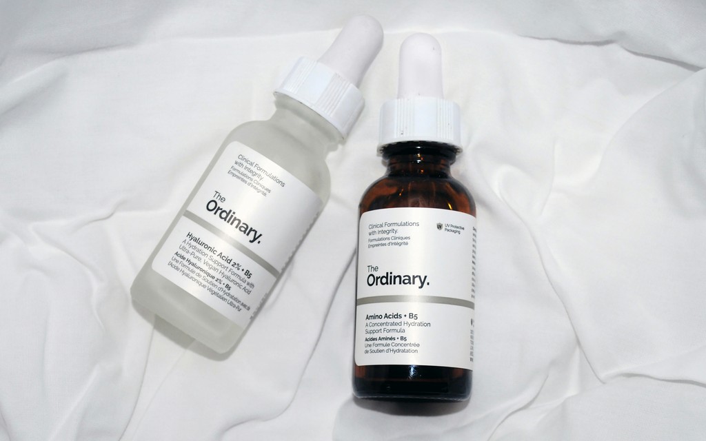 a couple of bottles of liquid sitting on top of a bed