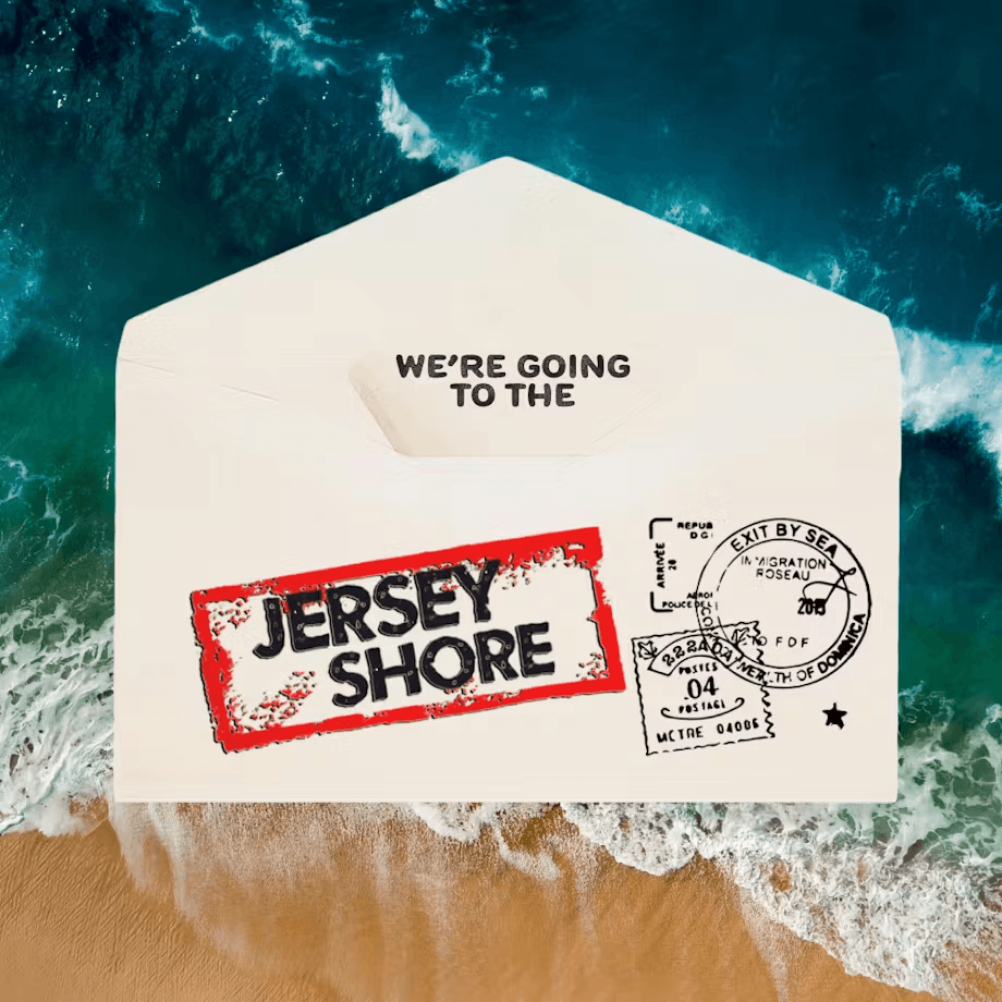 An envelope partially buried in sand near water, marked with a "Jersey Shore" stamp and postal details.