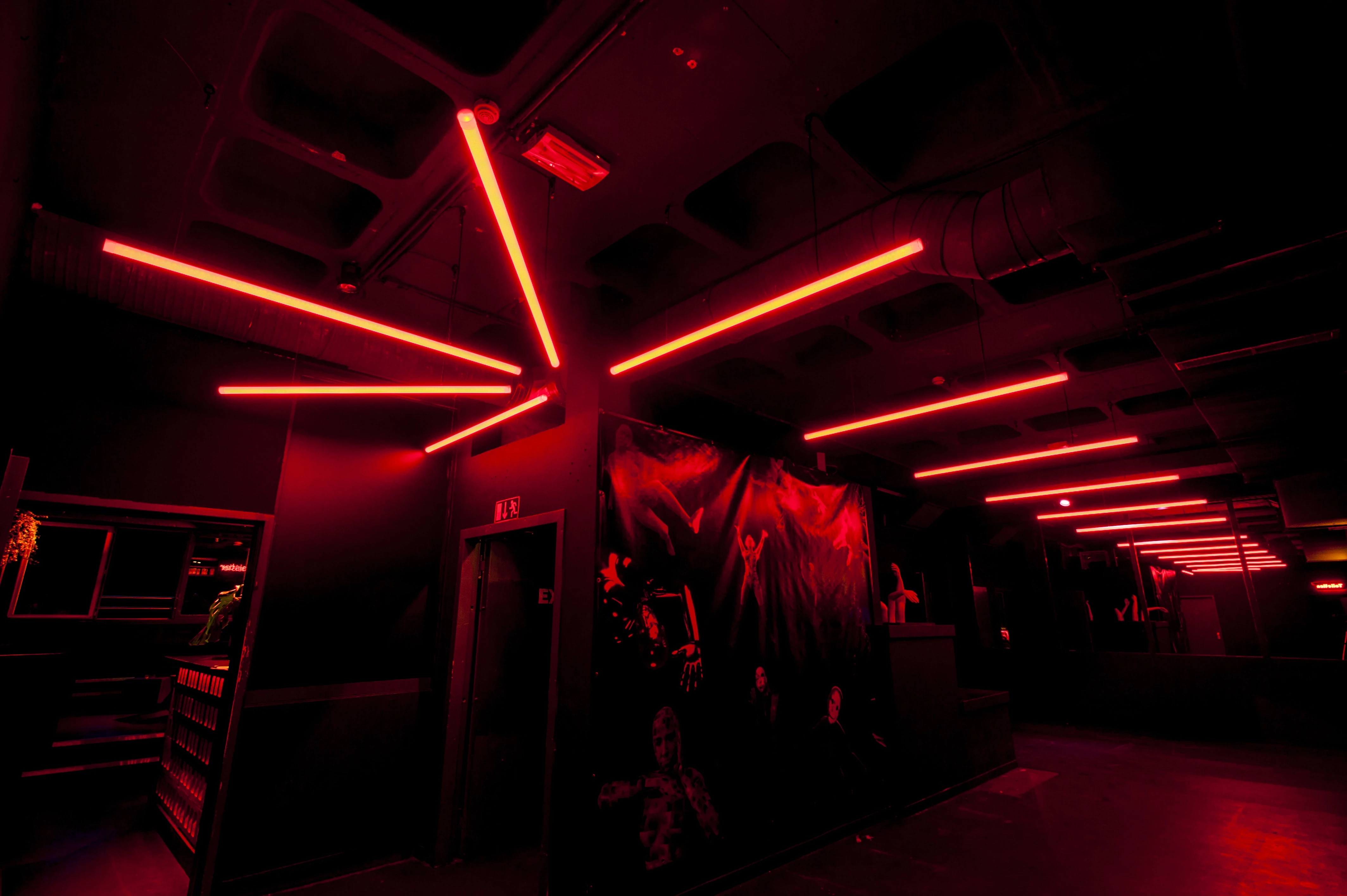 Red neon tubes fanning out across the dark ceiling of the Jägermeister Night Embassy club corridor.