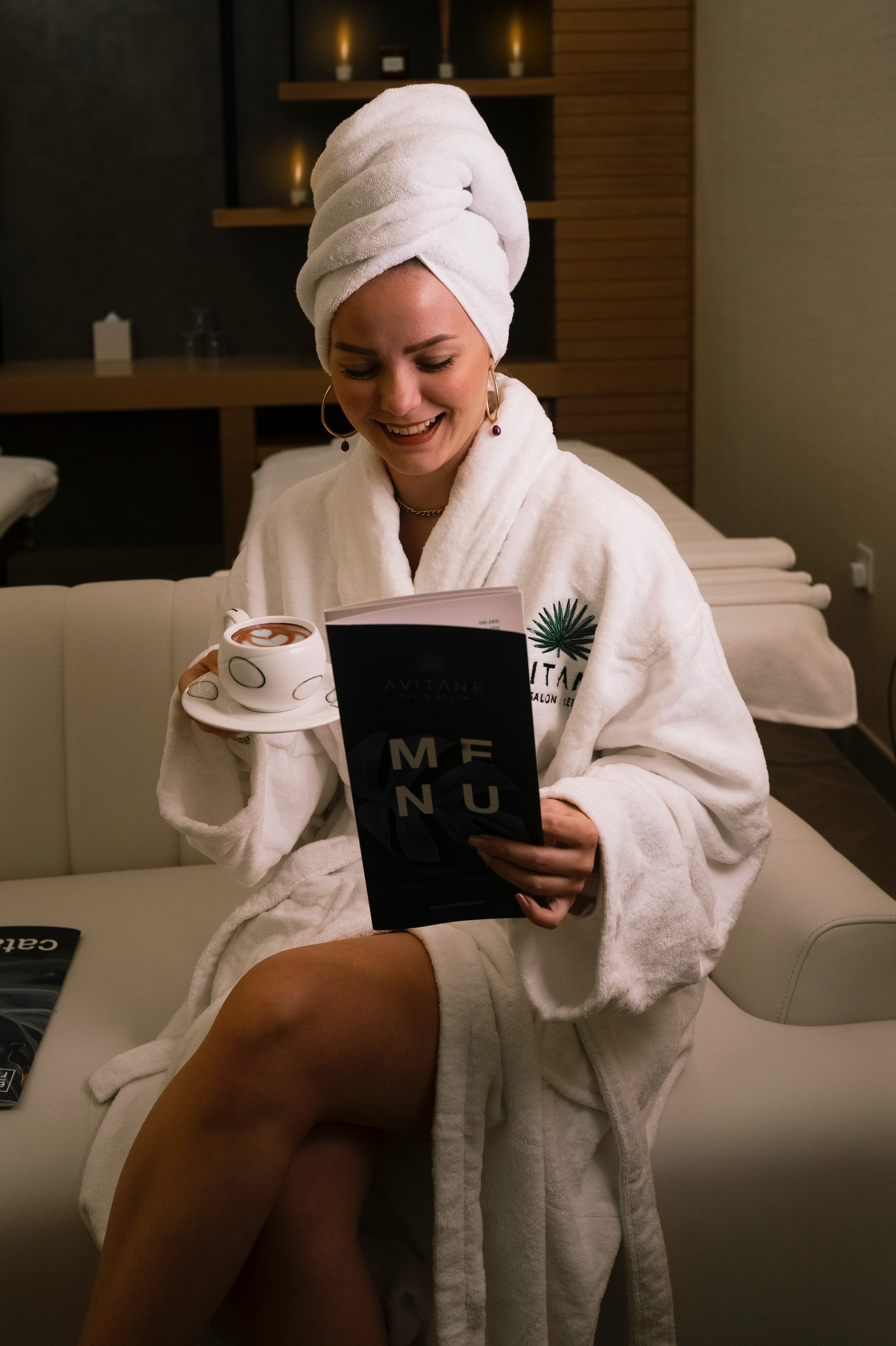 woman in white bathrobe holding black book