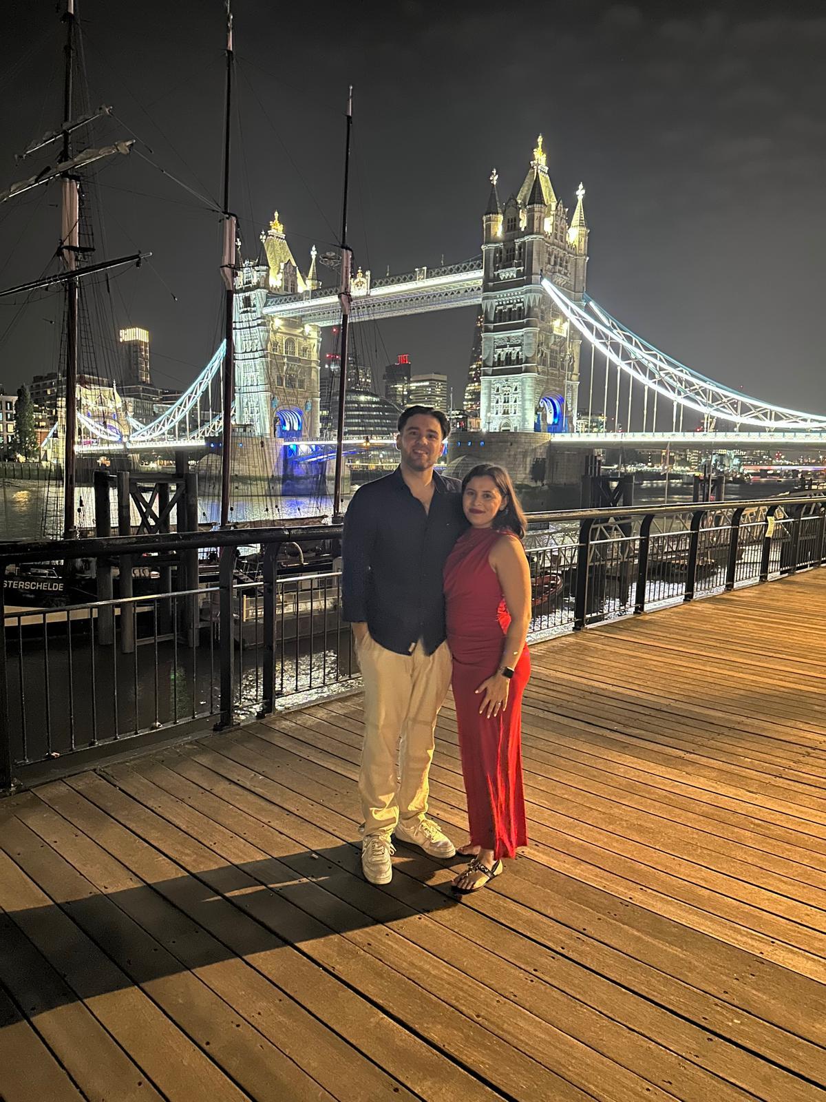 Close-up of two hands gently clasped, one wearing a sparkling engagement ring. The soft lighting and pastel nails evoke a sense of romance and intimacy.