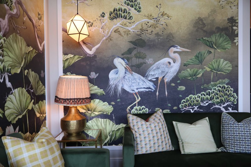 couches in front of bird mural