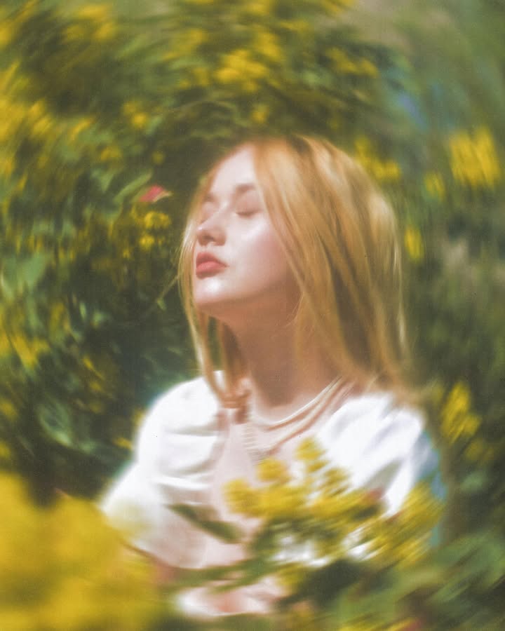 A woman in a straw hat stands in the grass