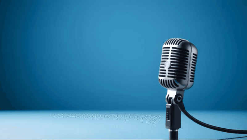 A single microphone in front of a blue background