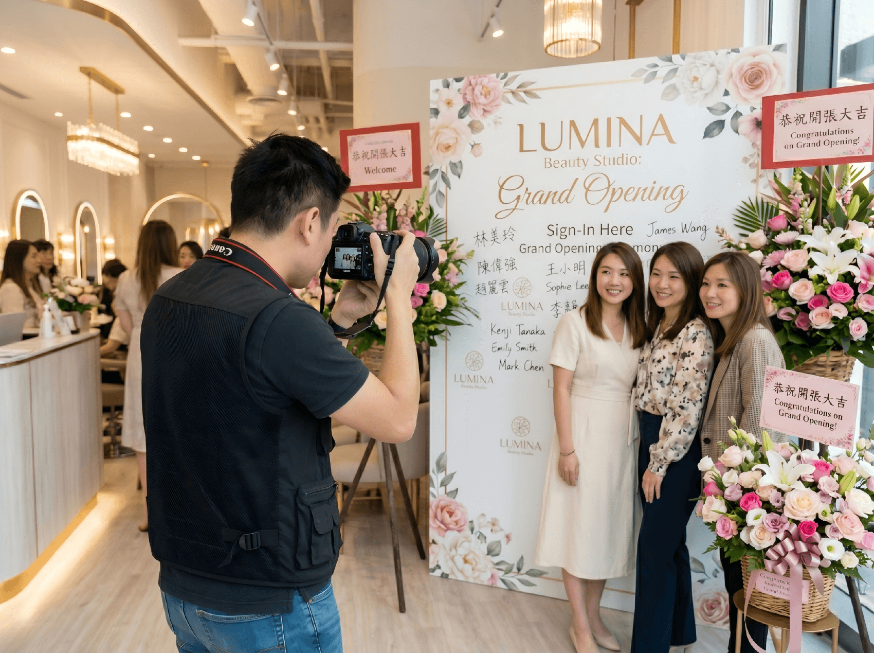 美容院開業現場男性攝影師為賓客拍攝合照，實景記錄品牌開幕典禮與簽到背景板 Beauty salon grand opening photographer capturing group photos of guests in front of a bright branded sign-in backdrop 開幕攝影 美容院開業活動實拍