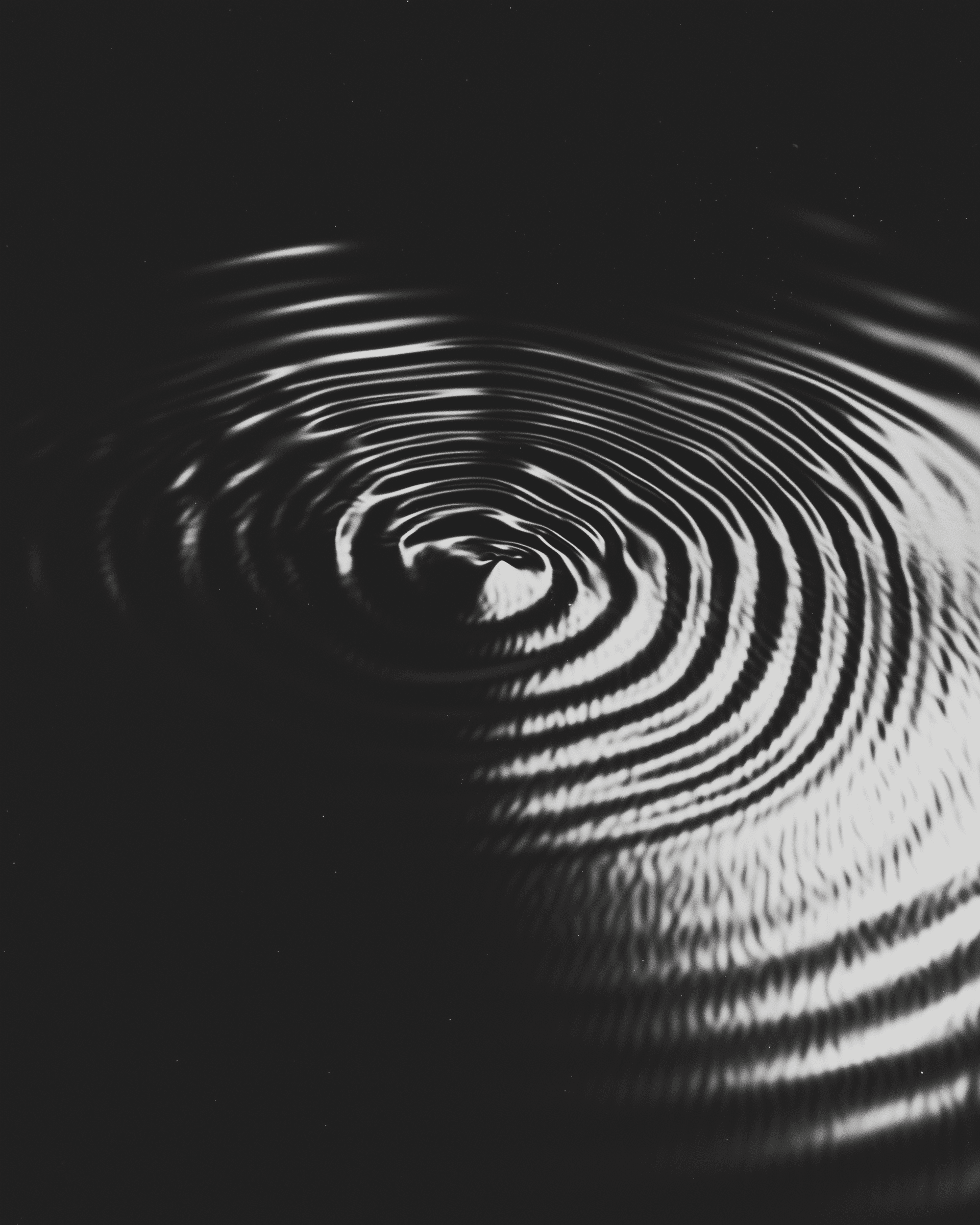 A black limousine parked at a gas station at night