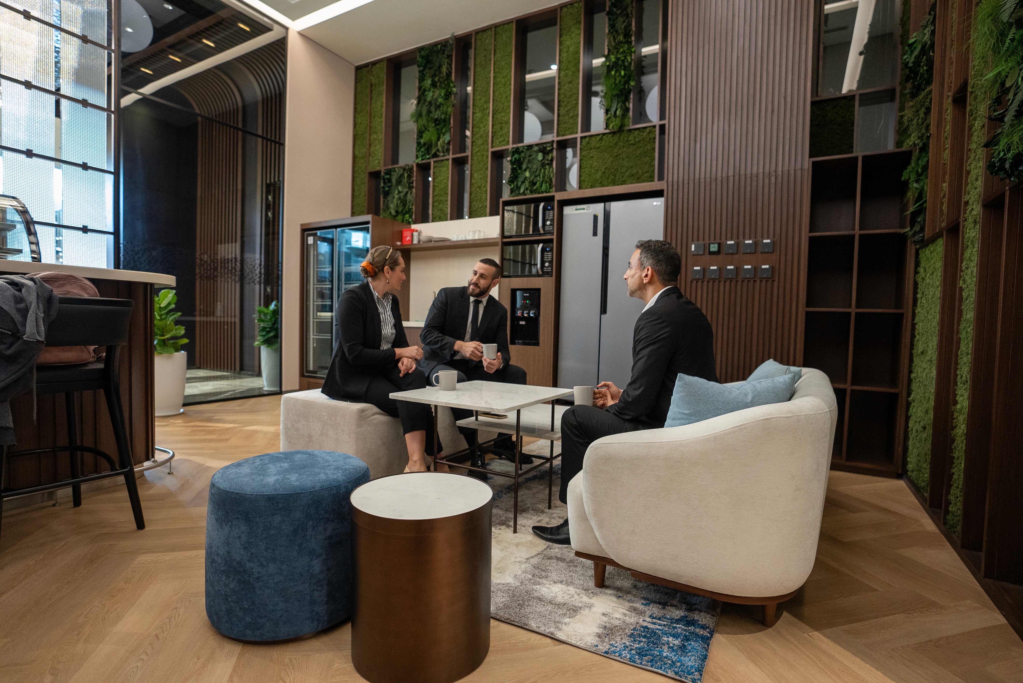 Clients having a discussion in a relaxed breakout space at Office Square’s serviced office in Dubai.