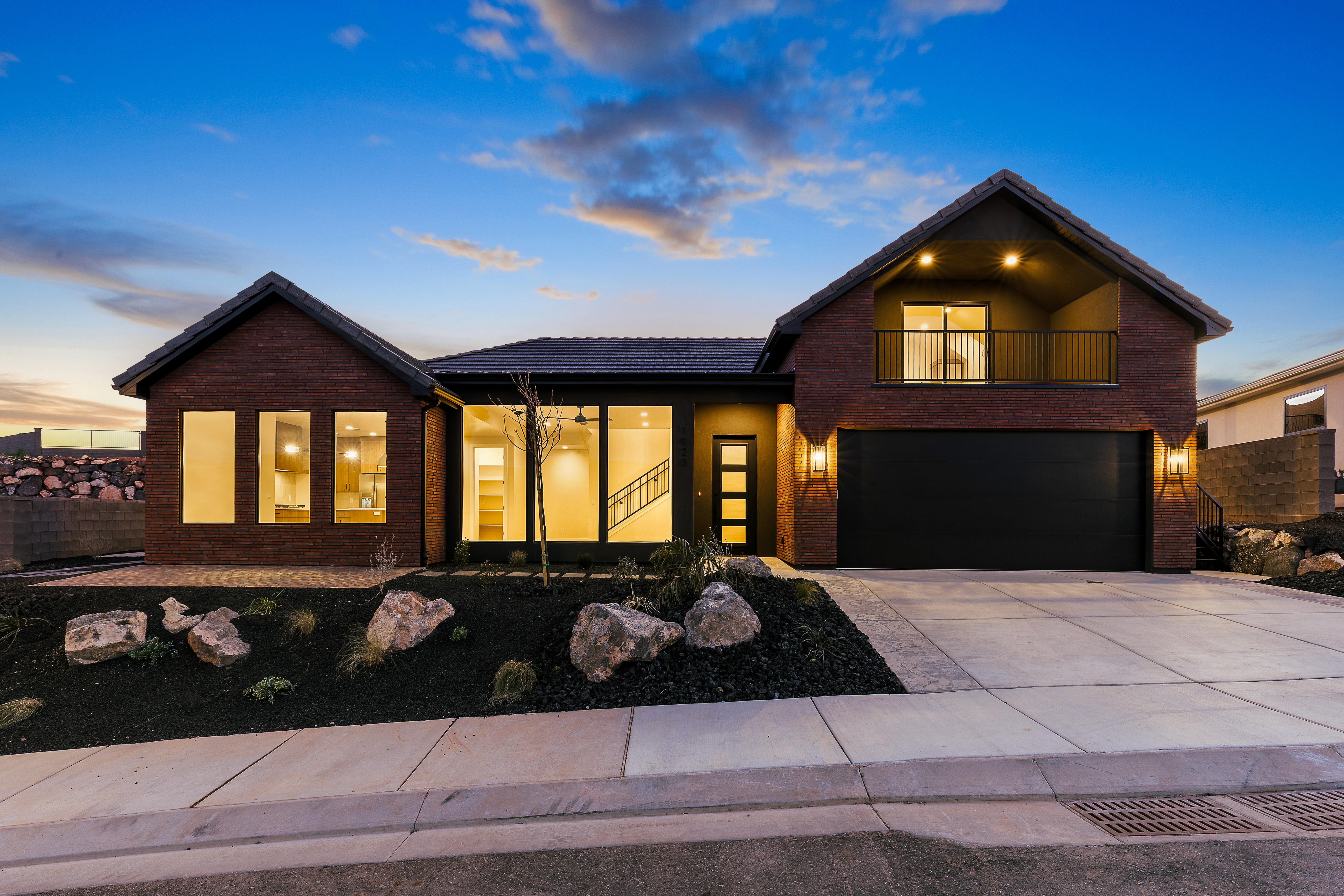Evening view of a Southern Utah custom home with warm lighting and modern exterior design