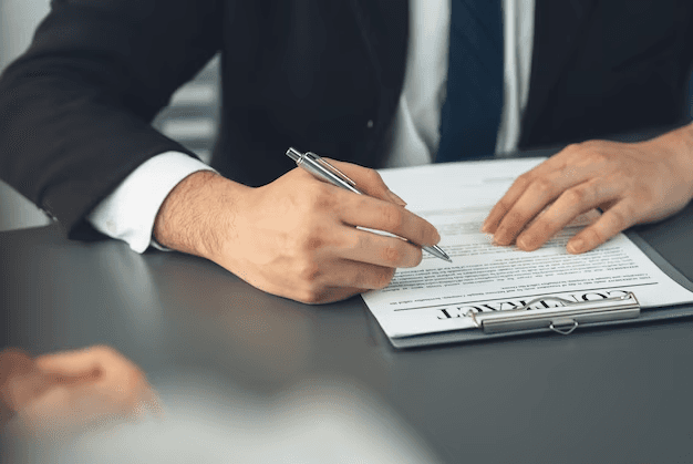 Suited male signing an Insurance Contract