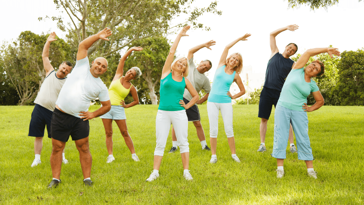 Several adults doing outdoor yoga
