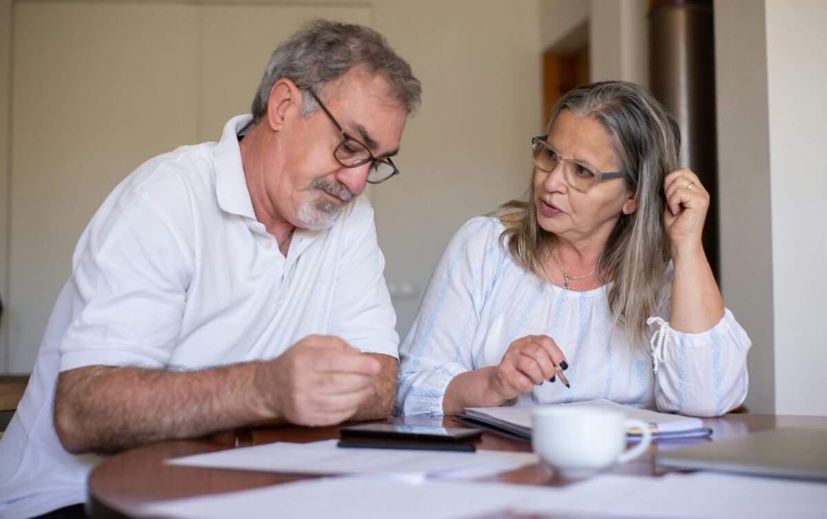 Parja mayor calculando impuestos en una mesa