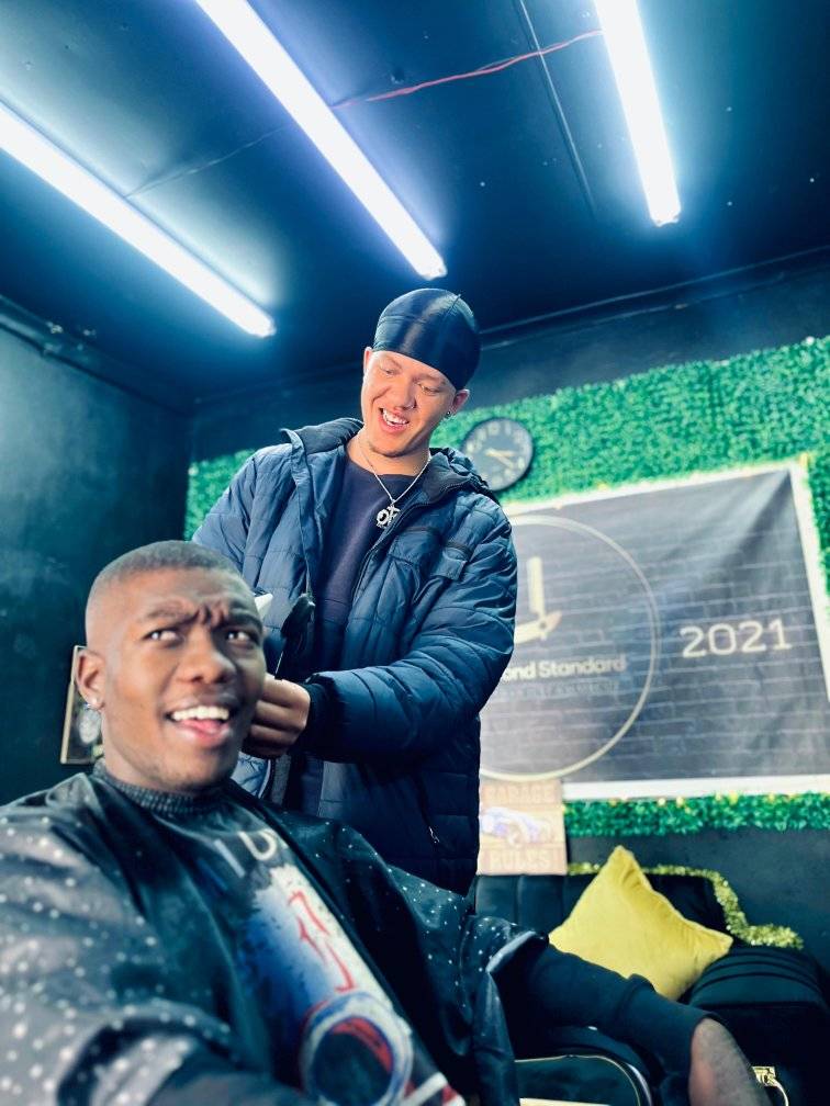 An image of Ethan Collins cutting one of his customers hair in the Diamond Standard