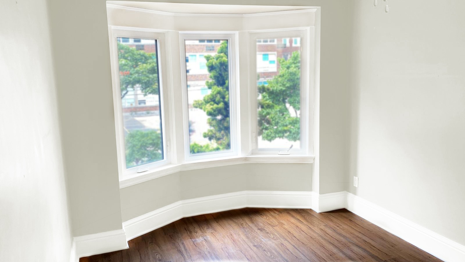 Freshly painted light beige room with a bay window