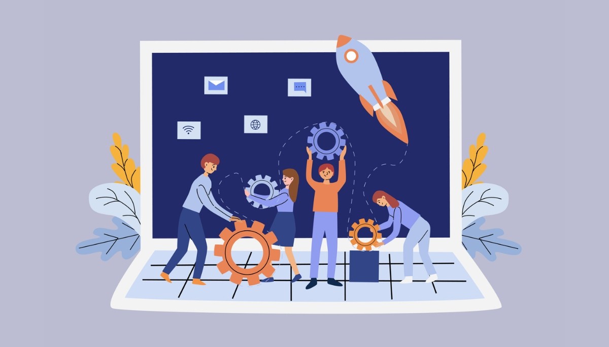 A team assembling gears in front of a laptop with a rocket launching from the screen.