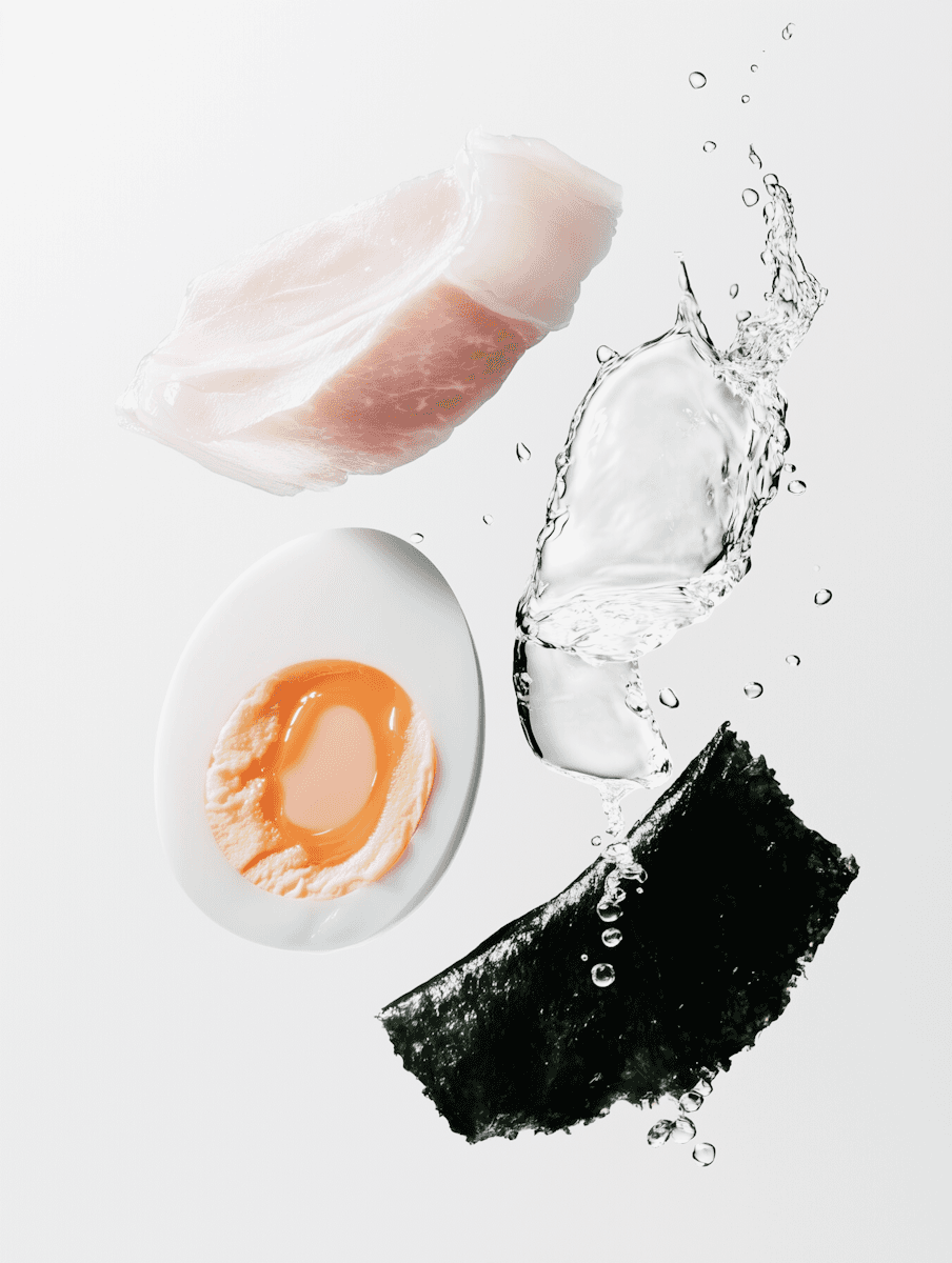 Fresh ingredients in motion: raw fish, soft-boiled egg, seaweed, and water splash on a clean white background.