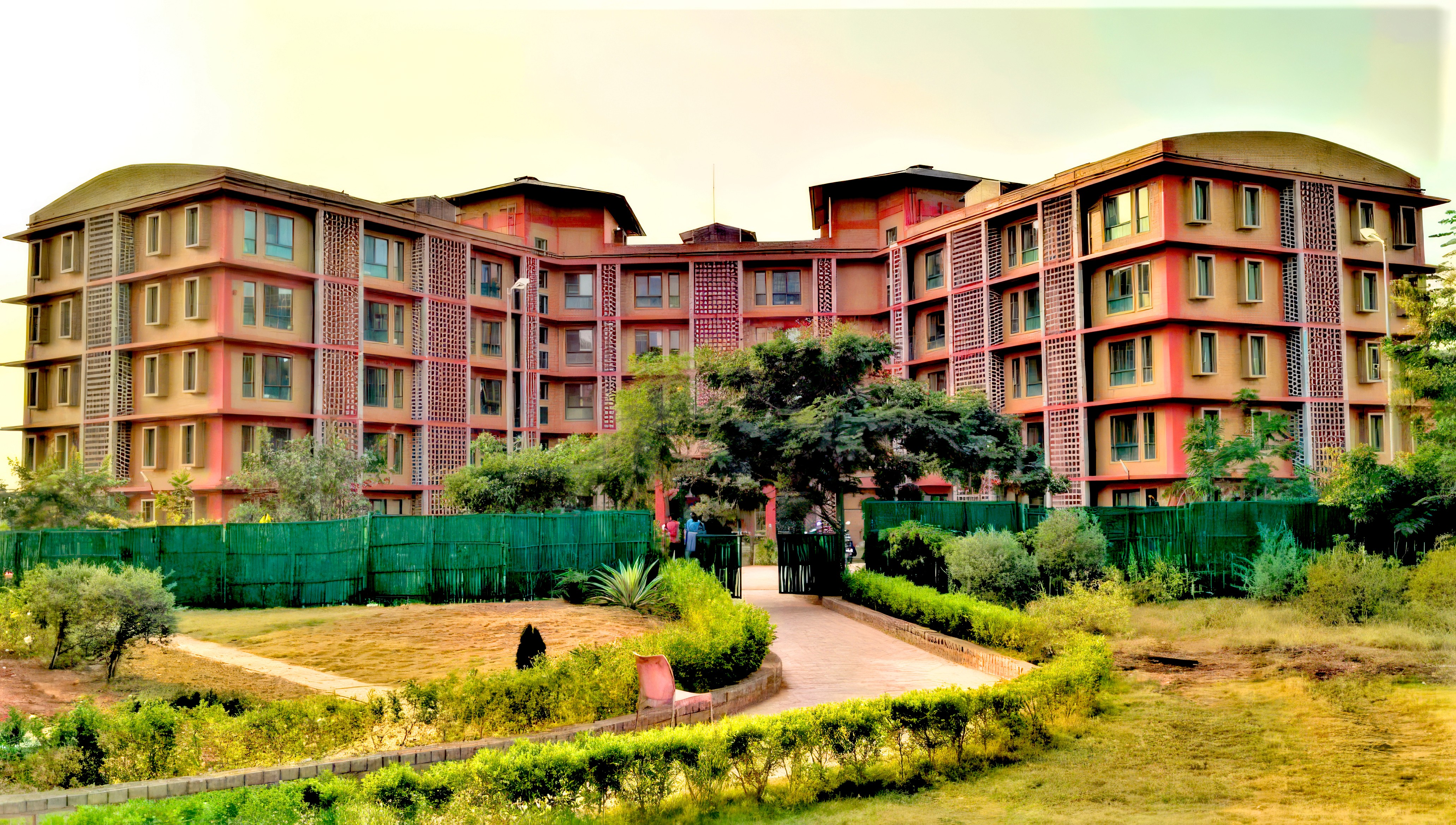 Aerial view of a winding road cutting through rocky terrain and sandy landscape.