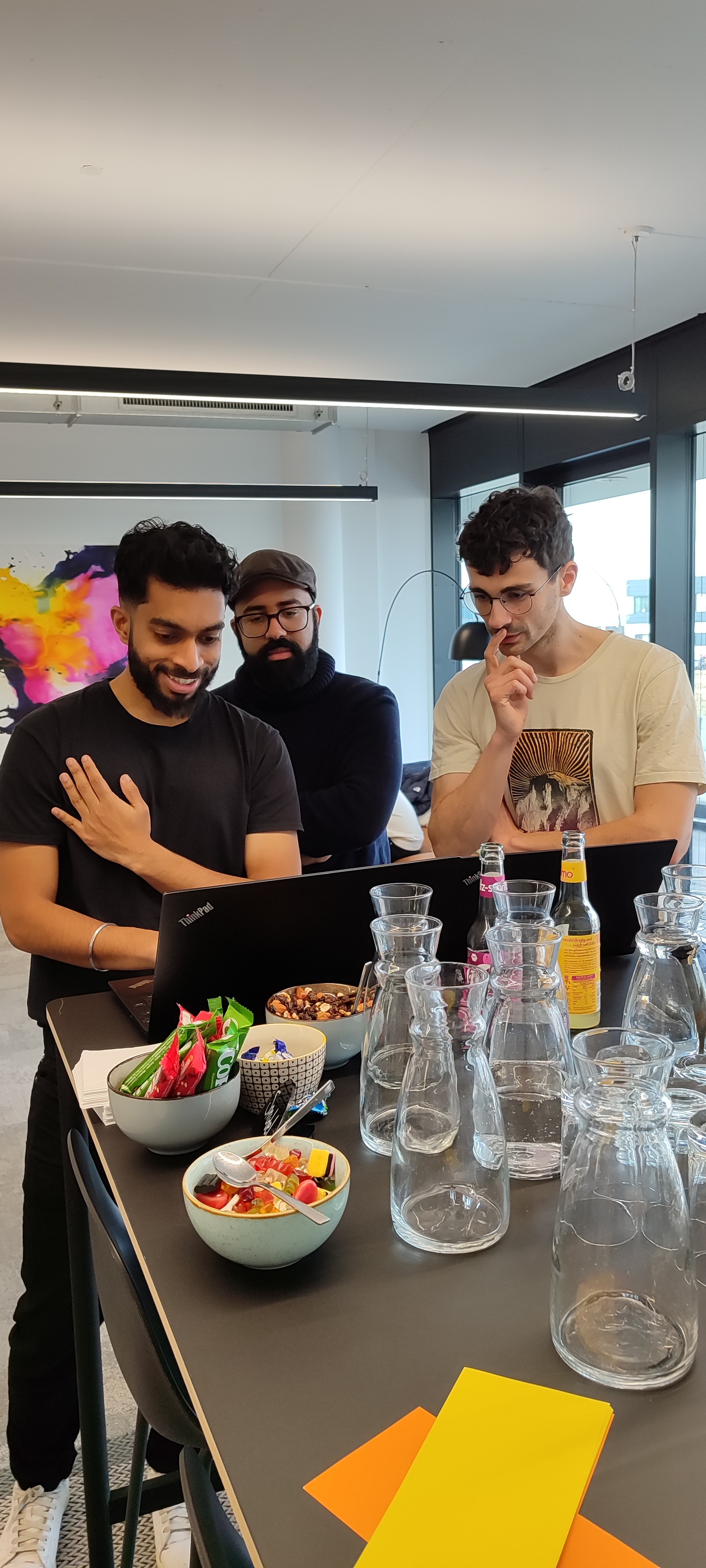 Colleagues gathered around a laptop.