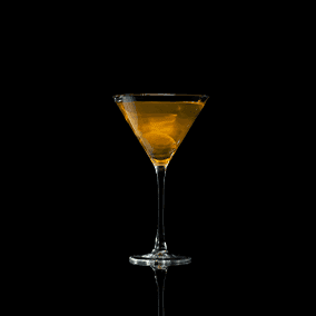 A closeup of a Dirty Martini drink against a dark background.