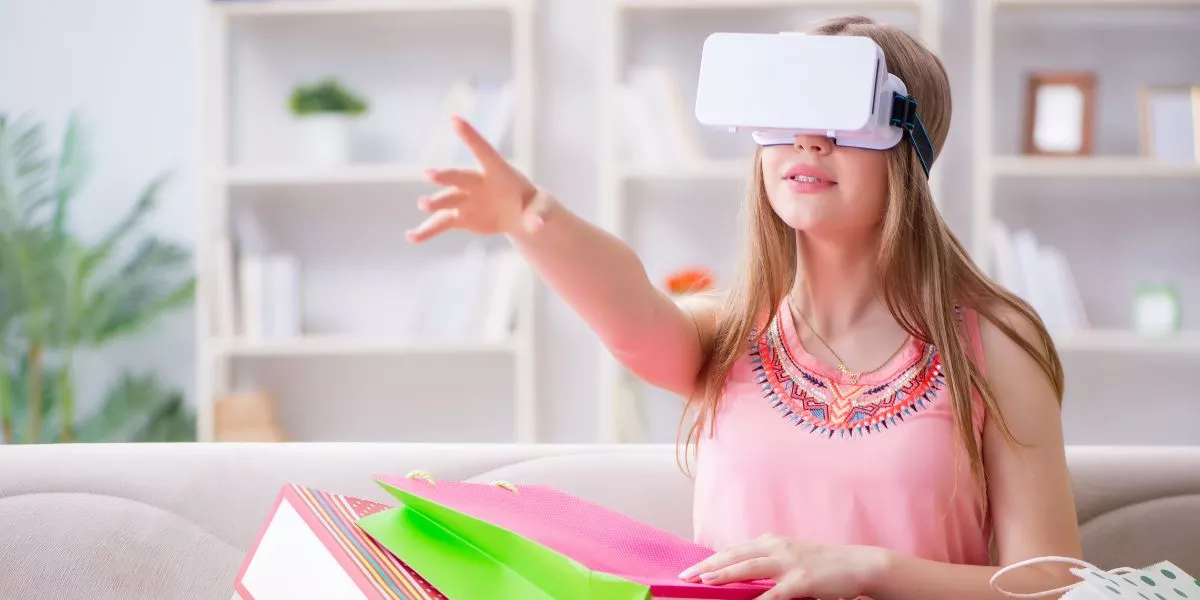 A man stands while two people sit at a table in an office setting, smiling and engaged in conversation. The mood is friendly and collaborative.
