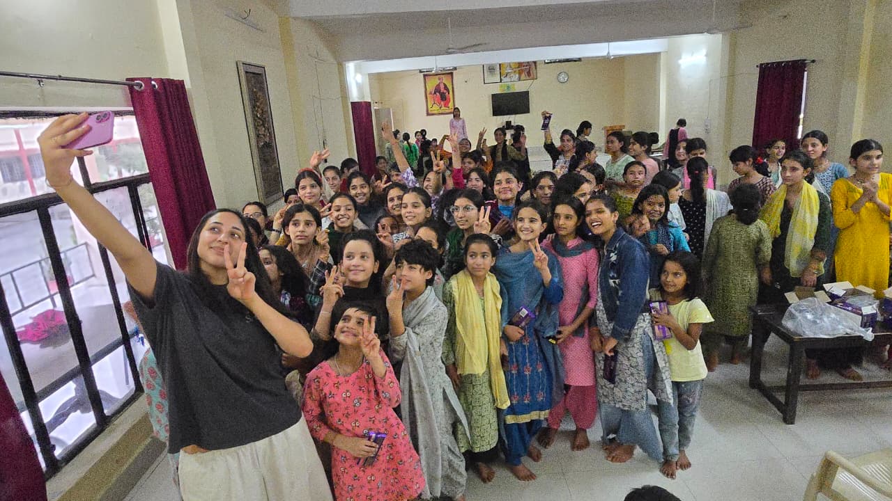 woman holding a phone and man looking at the phone. both are smiling