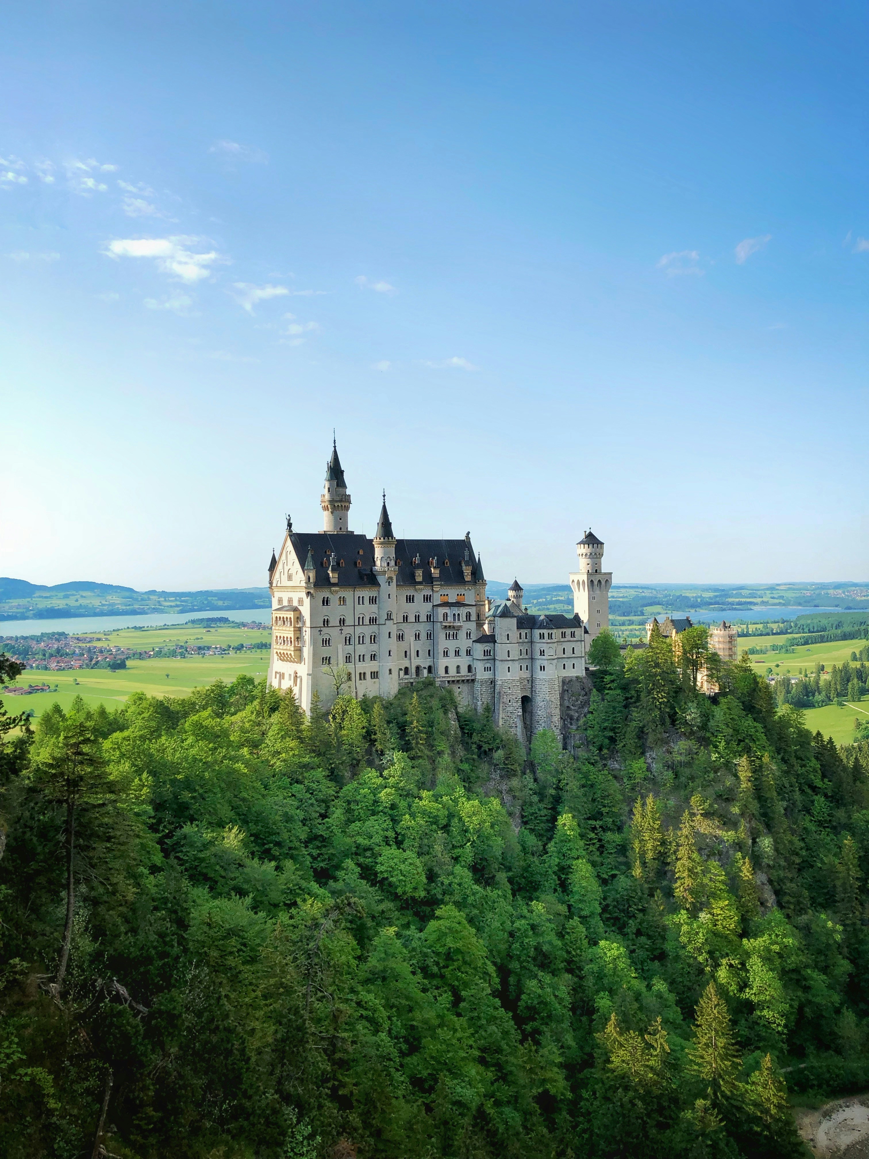 Schloss Neuschwanstein in Bayern, umringt von dichten Wäldern und mit Ausblick auf eine idyllische Landschaft, zählt zu den bekanntesten Reisezielen.