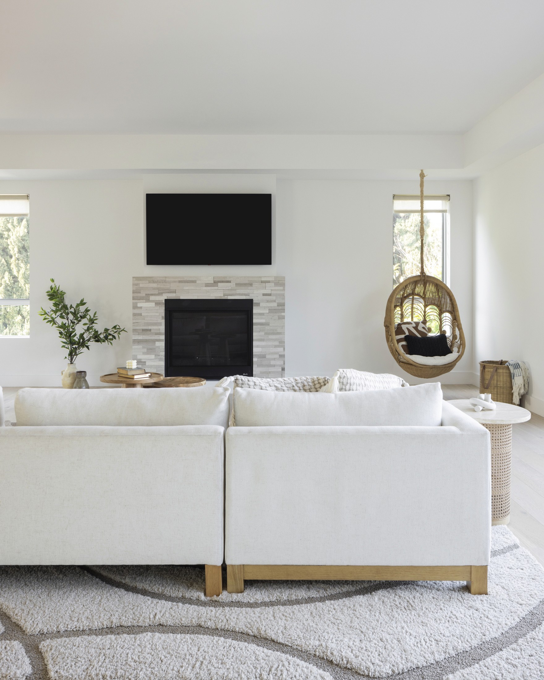 view of living room from back of sectional facing fireplace and accent chair in corner of room
