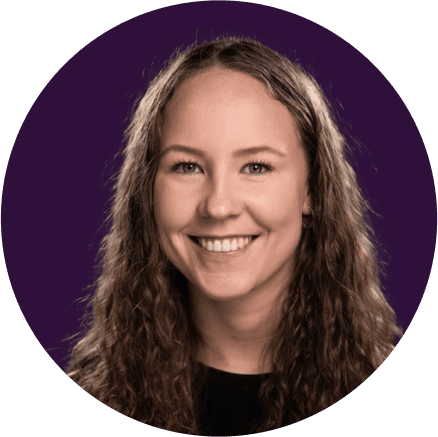 A woman with tousled brown hair wears round orange sunglasses and a floral-patterned blouse. Her expression is neutral, conveying a vintage vibe.