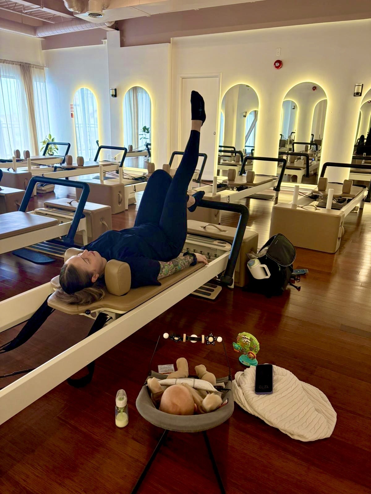 A woman balancing on a reformer in a boutique modern studio in Toronto