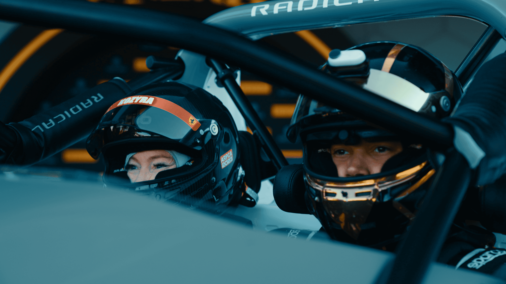 Suellio Almeida Sitting in Radical Racecar with Teammate