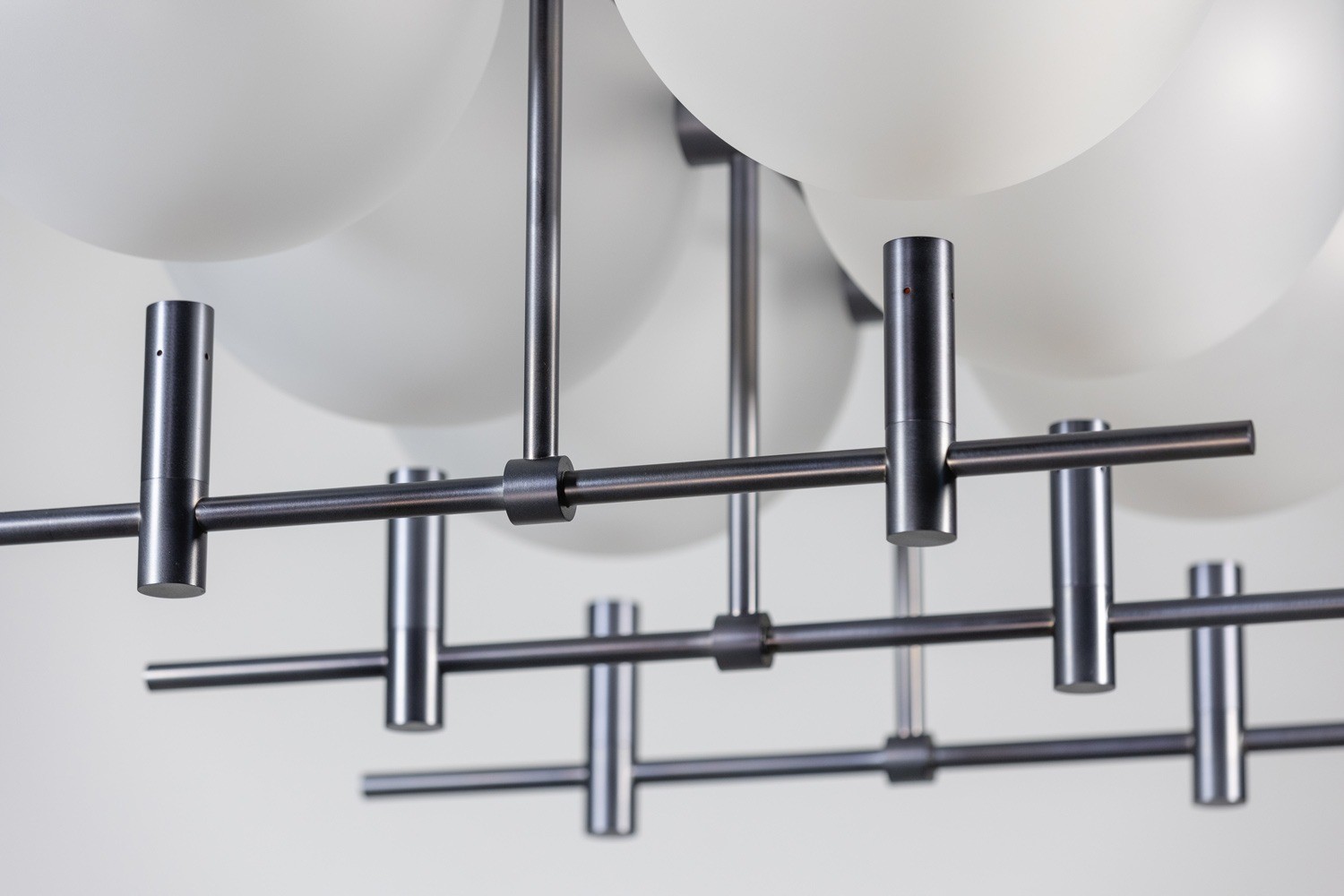 Luna II luminaire detail showing suspended glass spheres within metal structure by Jiri Krejcirik