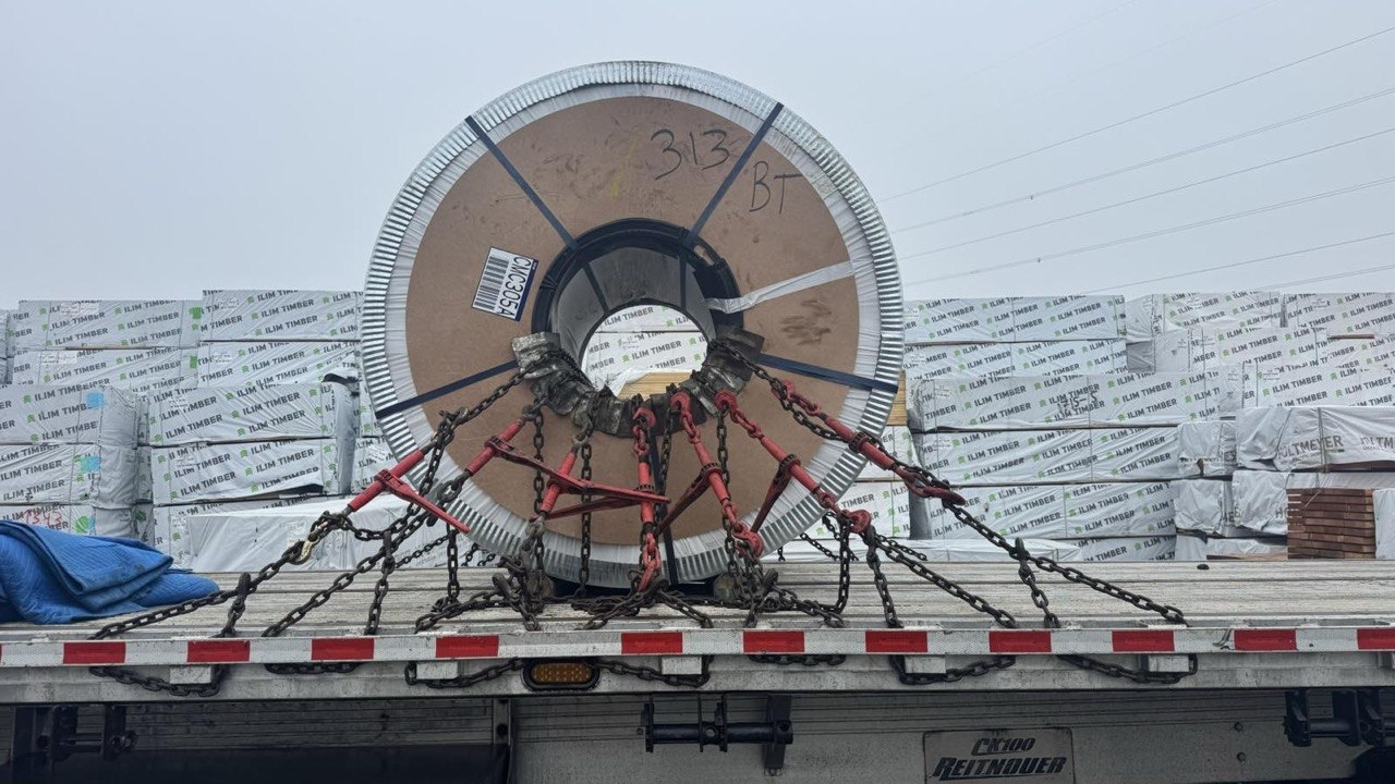 Steel coil secured on a flatbed trailer.