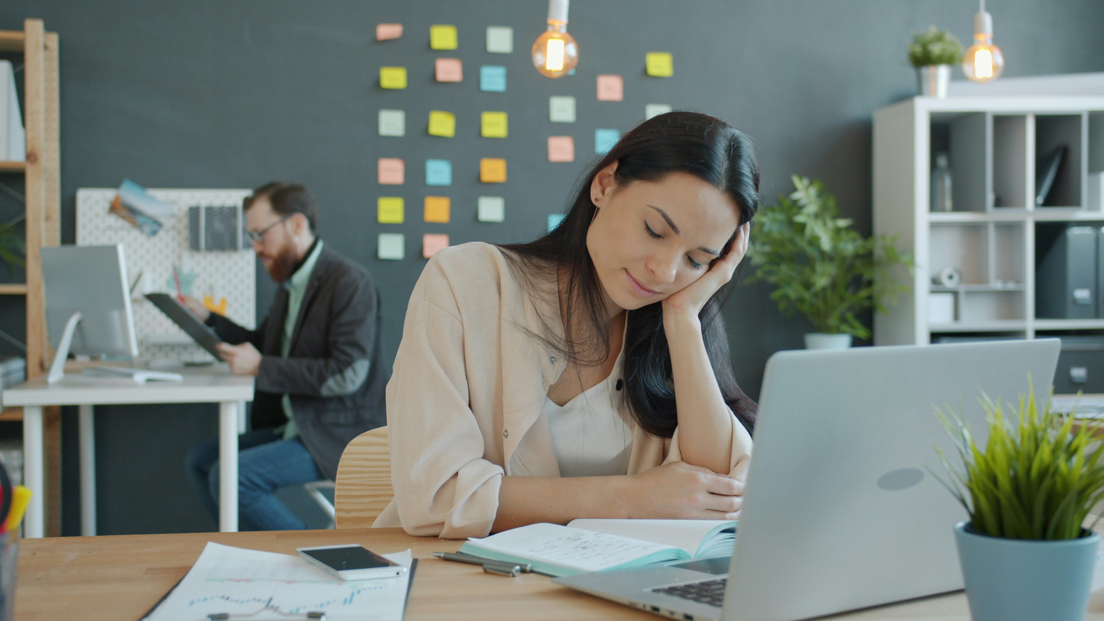 Woman resting head on hand at desk
