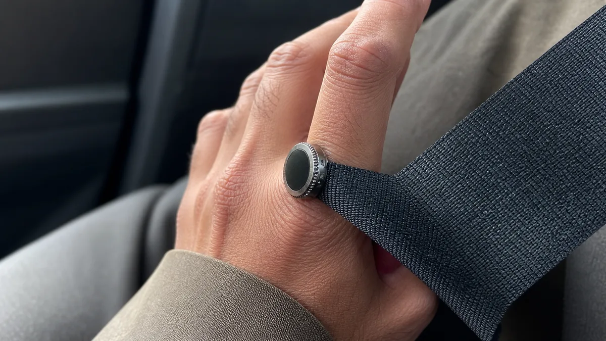Smart zikr ring bezel catches on a car seat belt, suggesting an accidental count