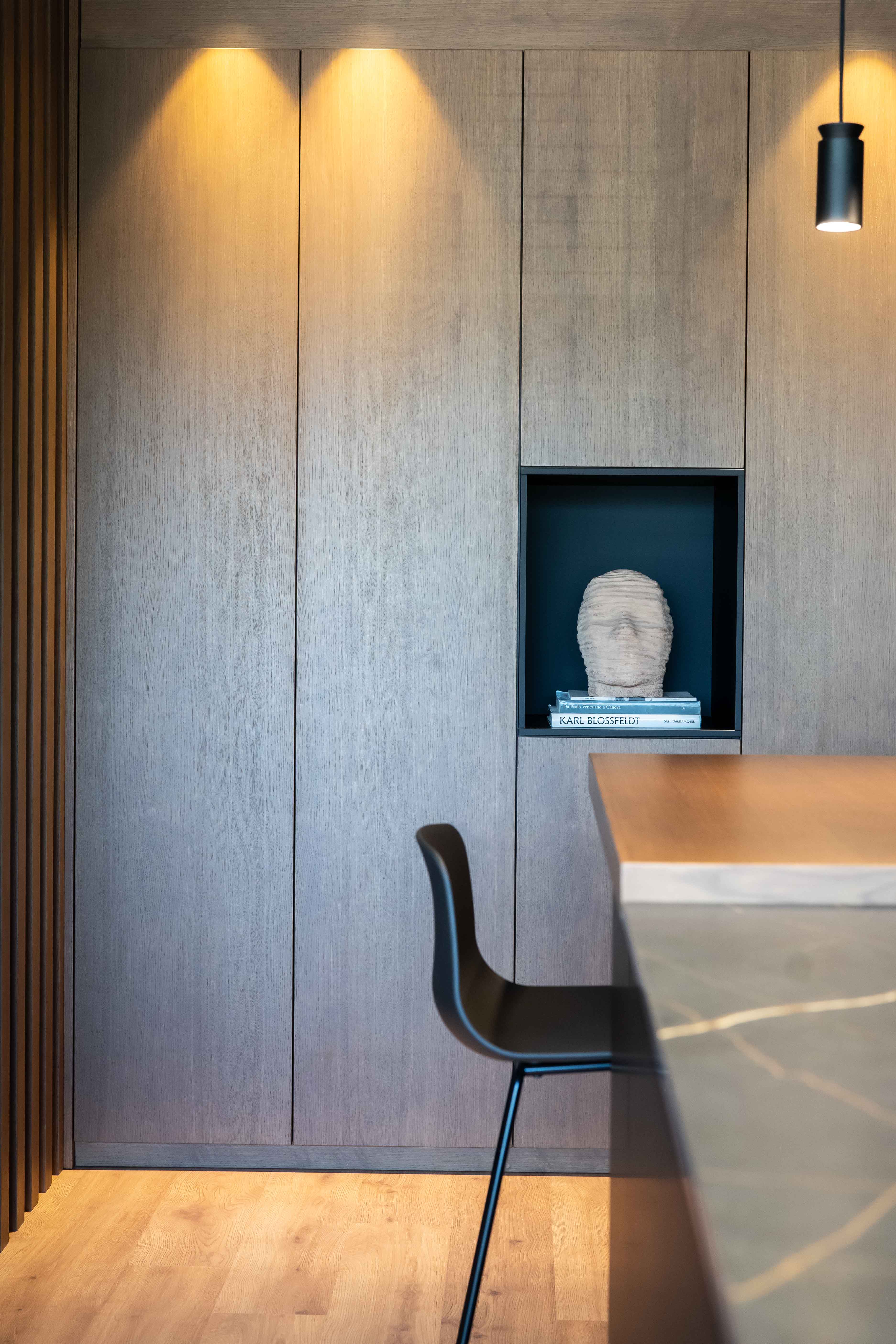 Detalle de cocina-comedor abierta de estilo oscuro con muebles y encimera de acabados negros