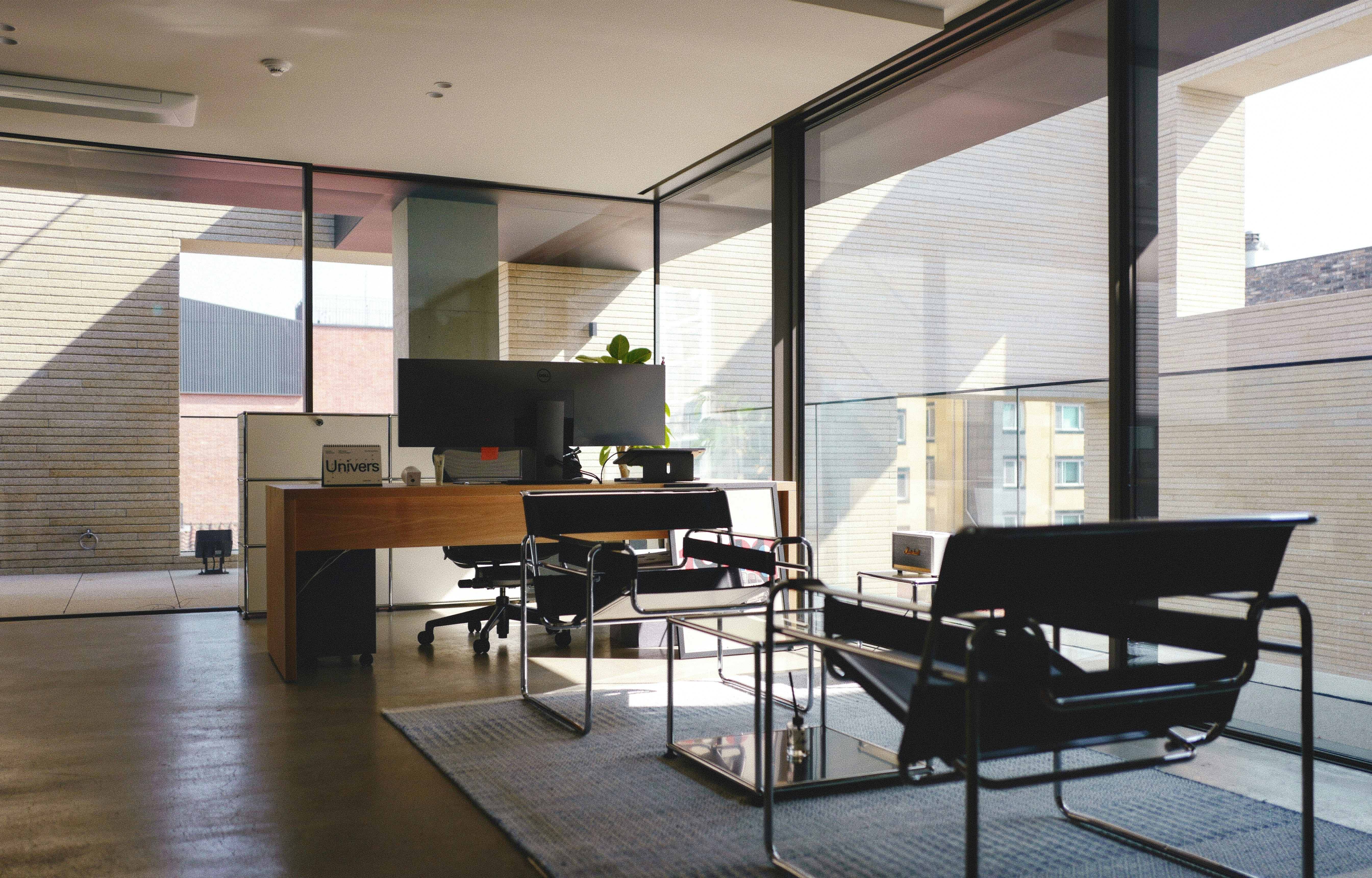 a room with a desk, chairs, and a television