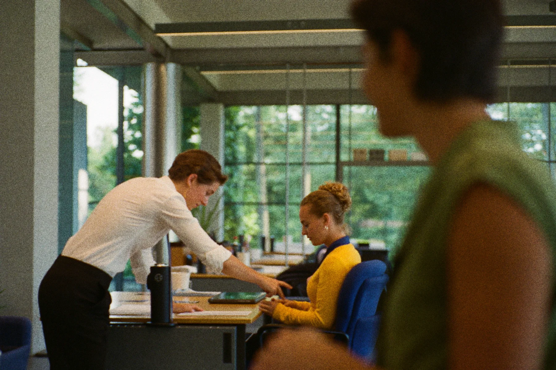 Twee binnendienst medewerkers buigen samen over een papieren checklist aan een werkbureau.