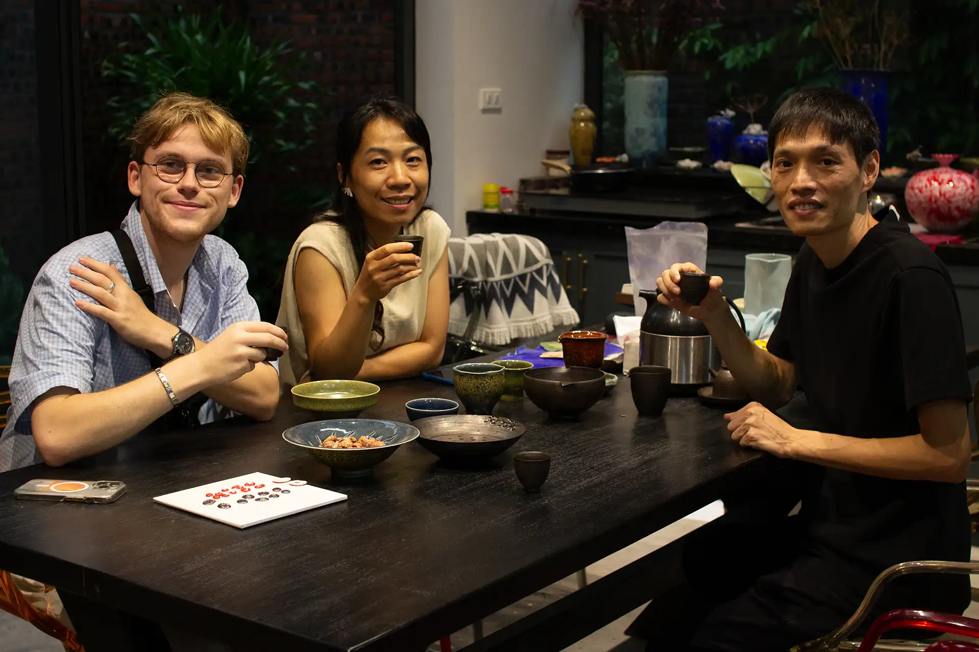 Yannik drinking tea with two people on a table in a living room