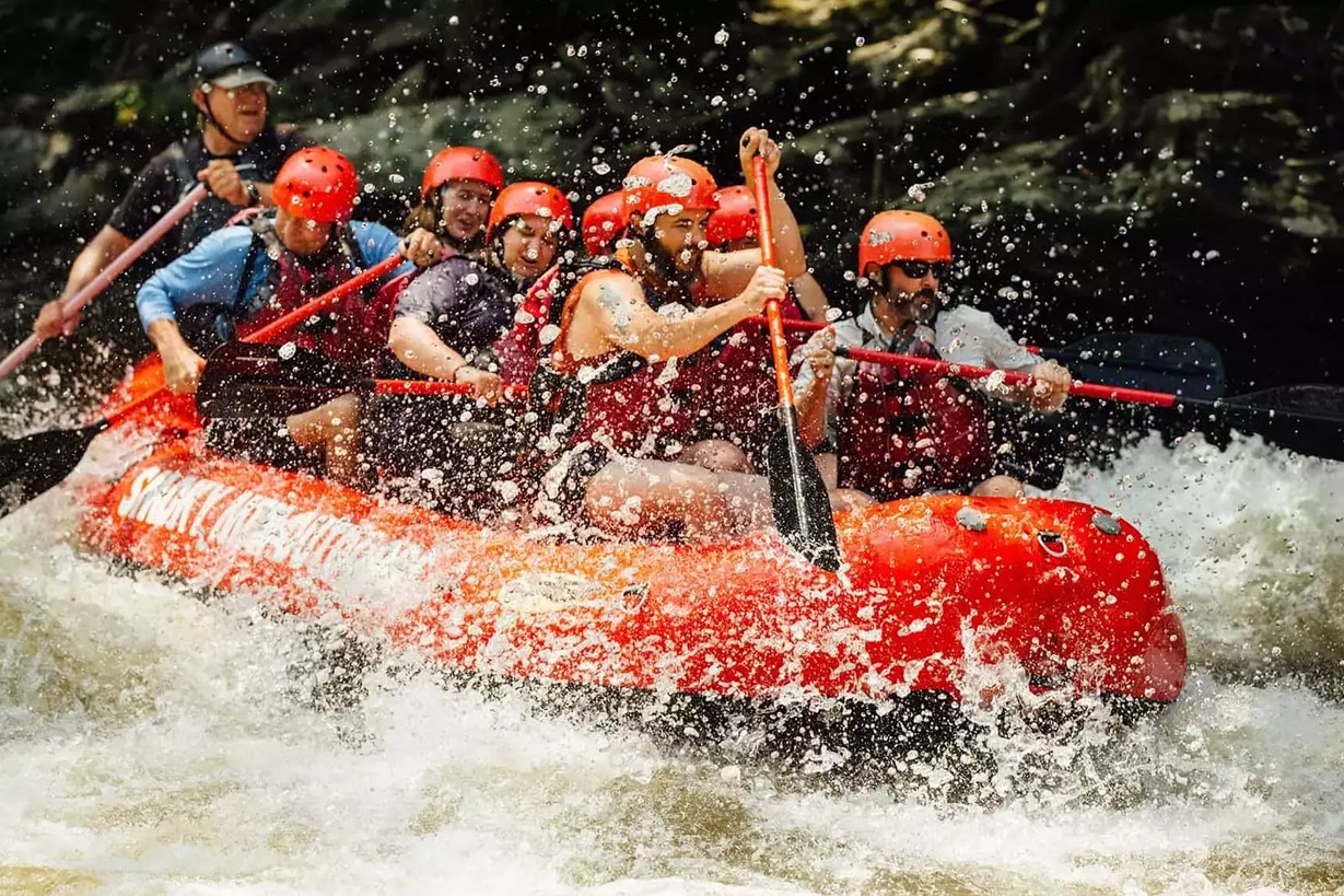 Awesome action and water spray as rafters splash through rapids