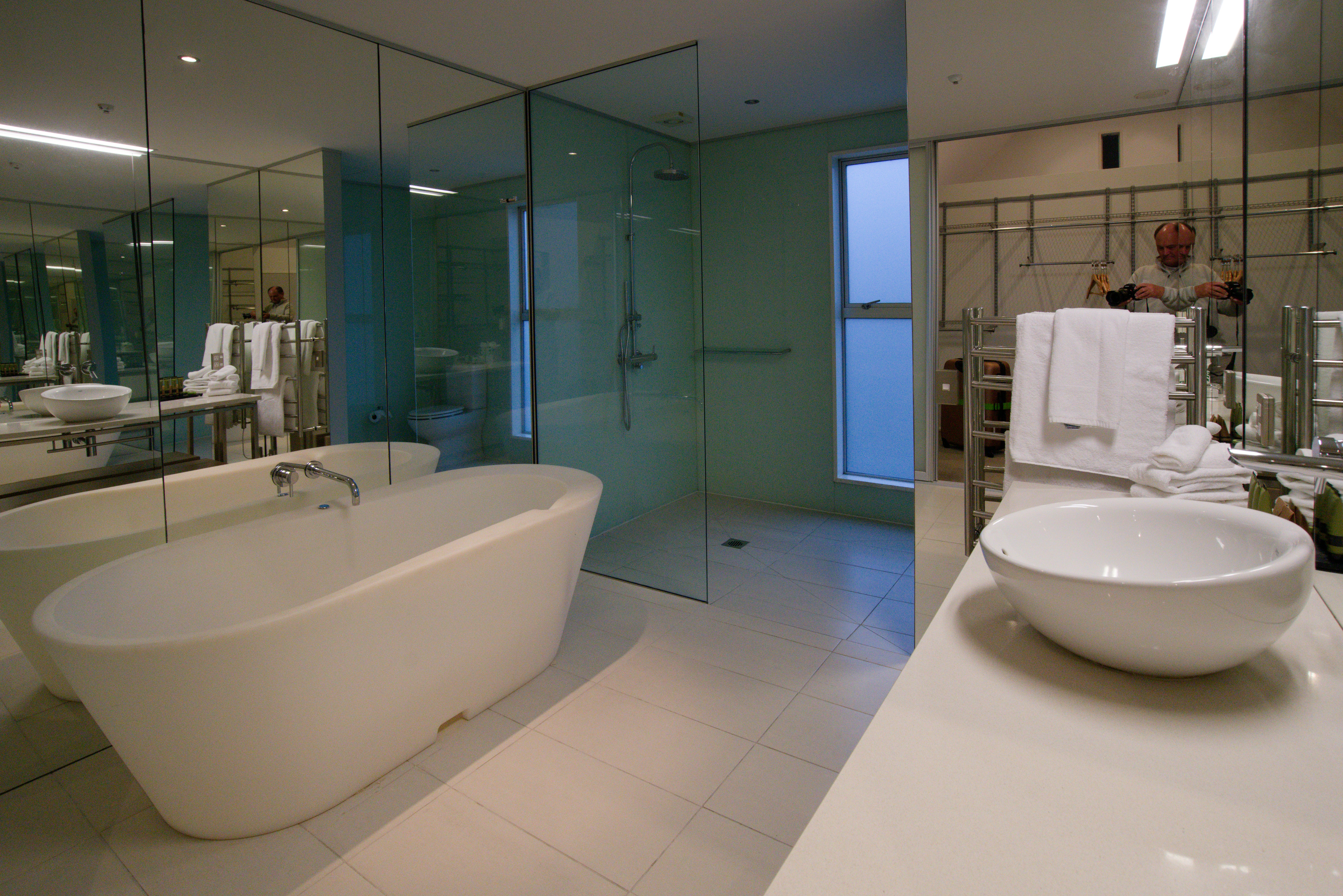 a bathroom with a tub, sink and mirror