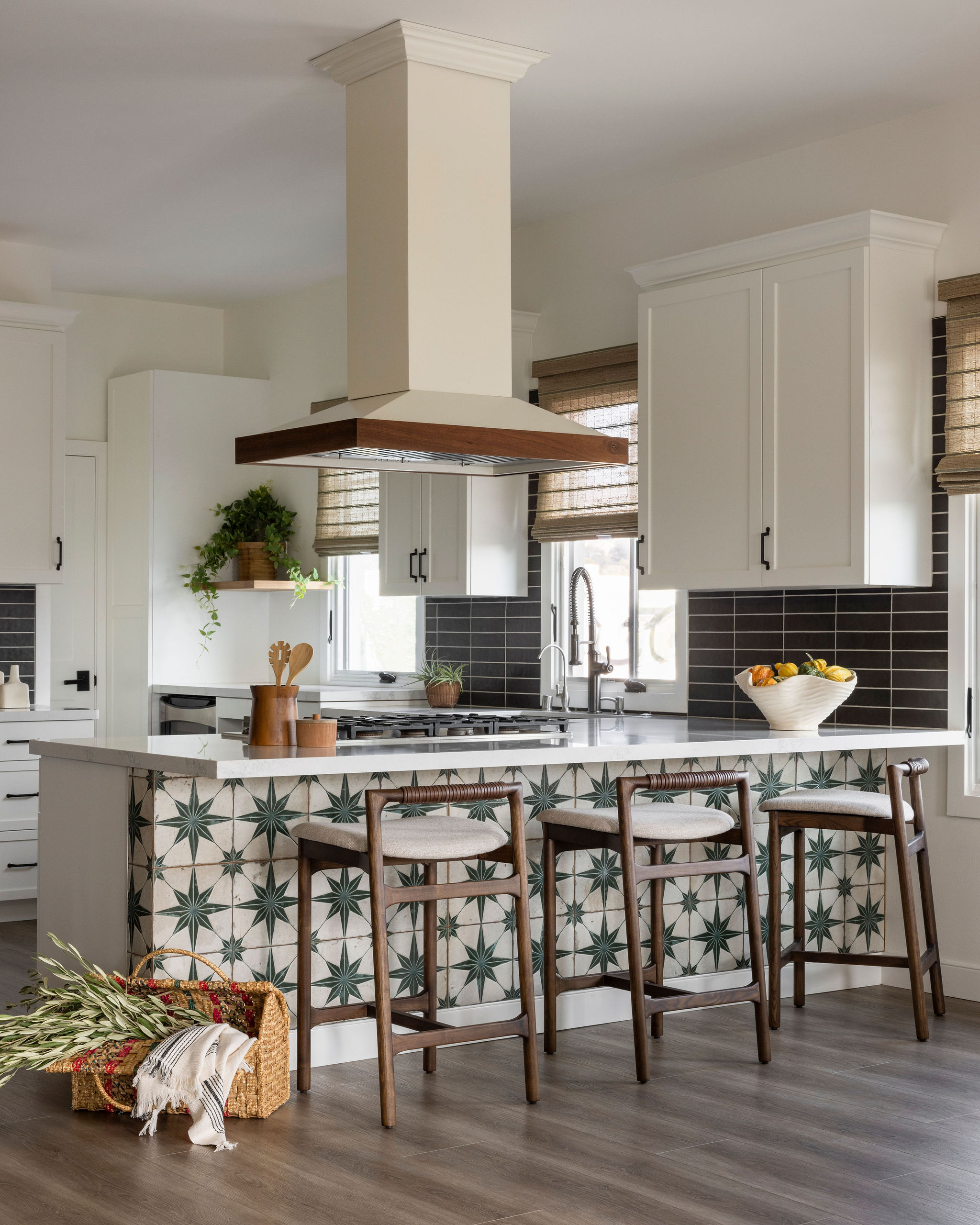 Bright and airy kitchen with white cabinetry, a large island, and natural wood and bold tile accents that evoke coastal charm.