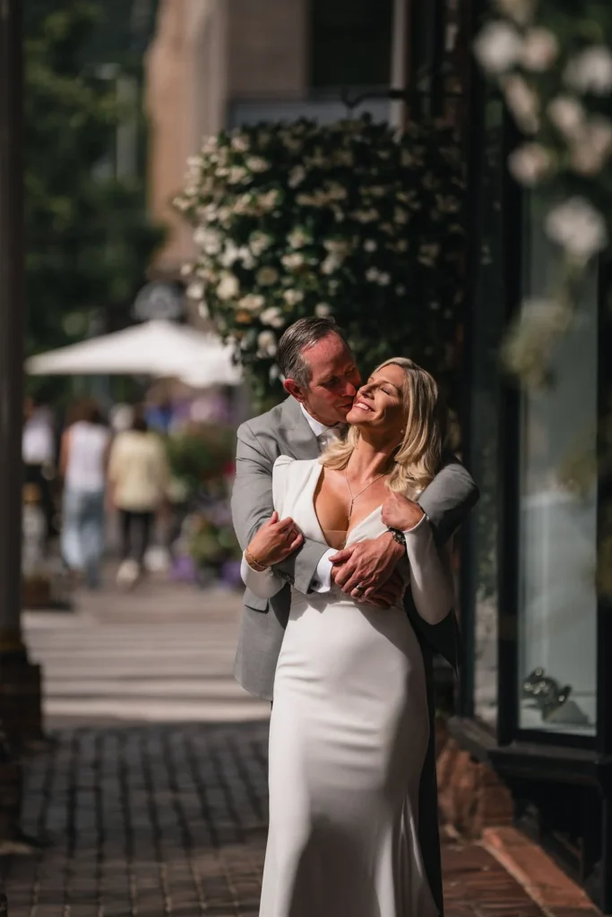 Newlyweds embracing on a downtown sidewalk