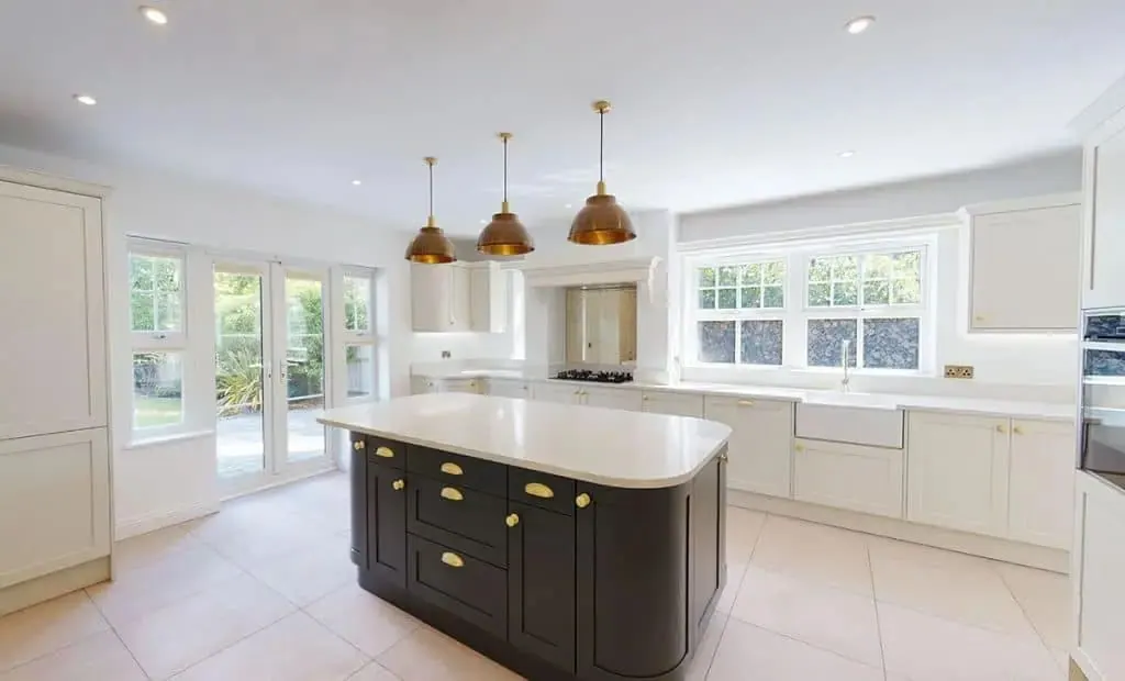 Dark painted kitchen island against an exposed brick wall