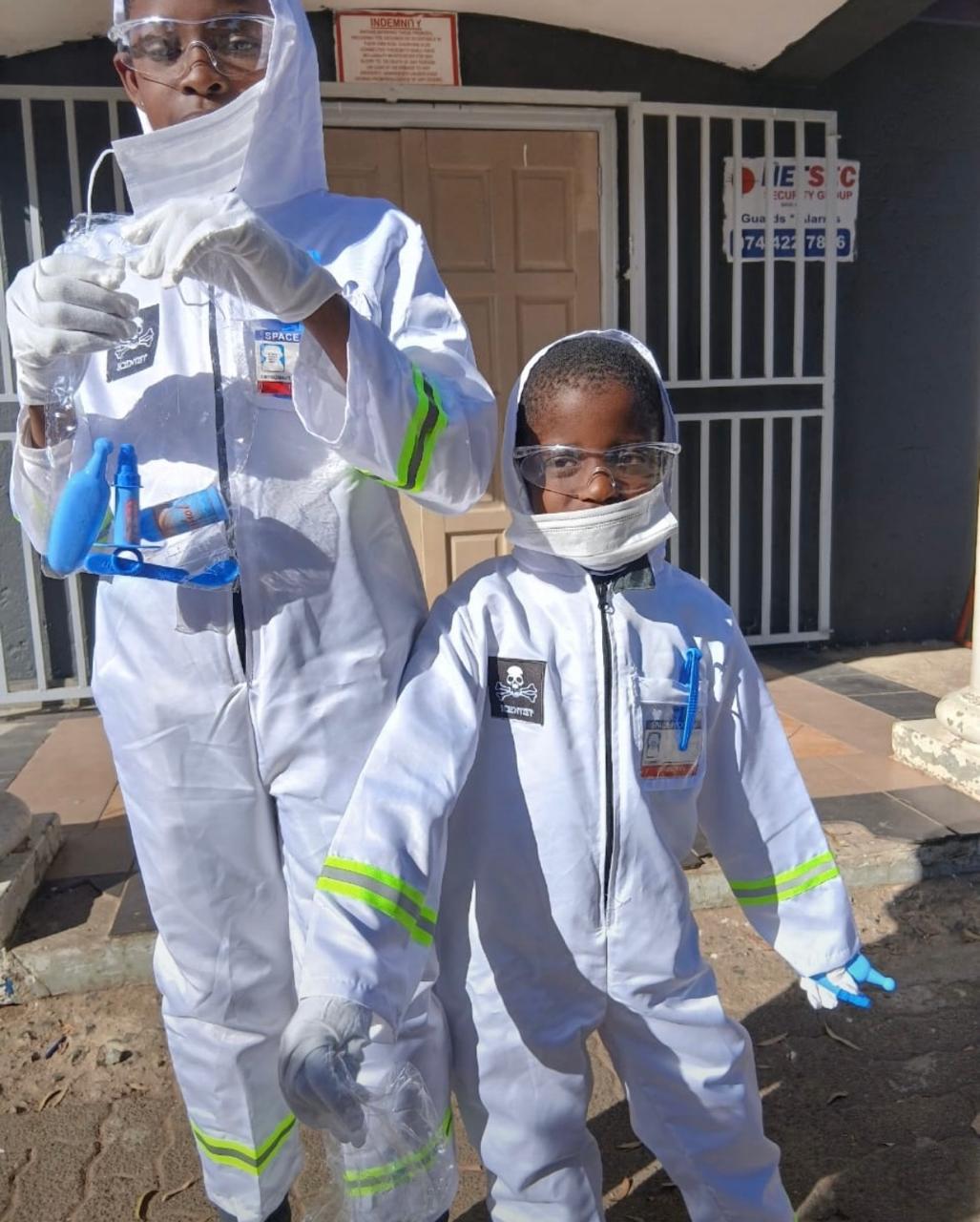 Two fathers carrying children on shoulders on a mountain path.